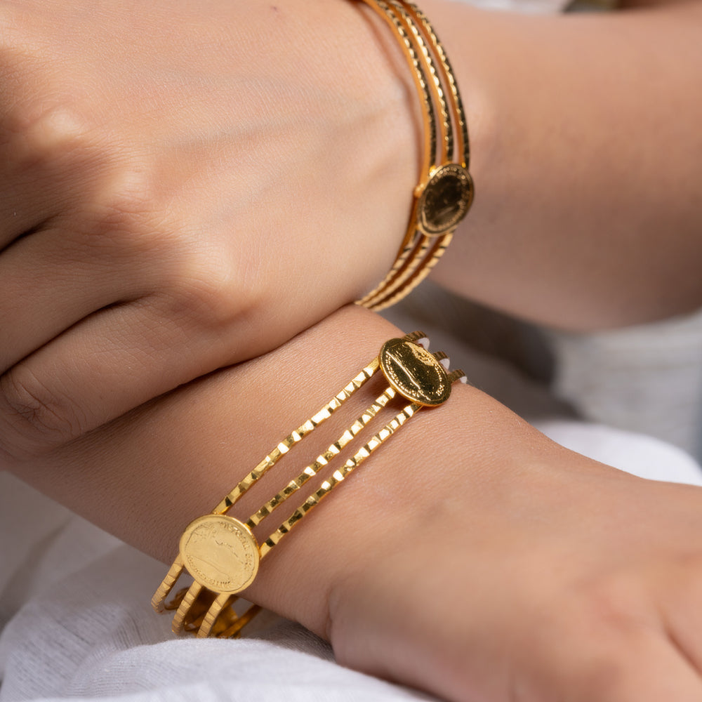 LOOK AND ADORN gold plated bangle set with stacked coin charms on female wrists styled with white linen