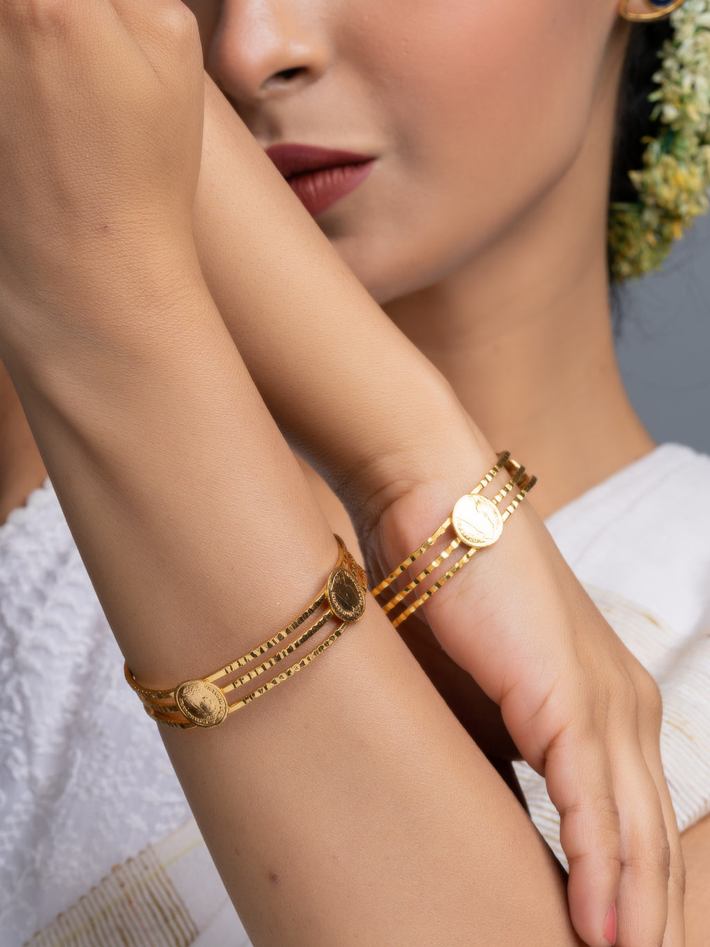LOOK AND ADORN gold plated bangle twin set with triple strand coin motif bracelets on model wrist