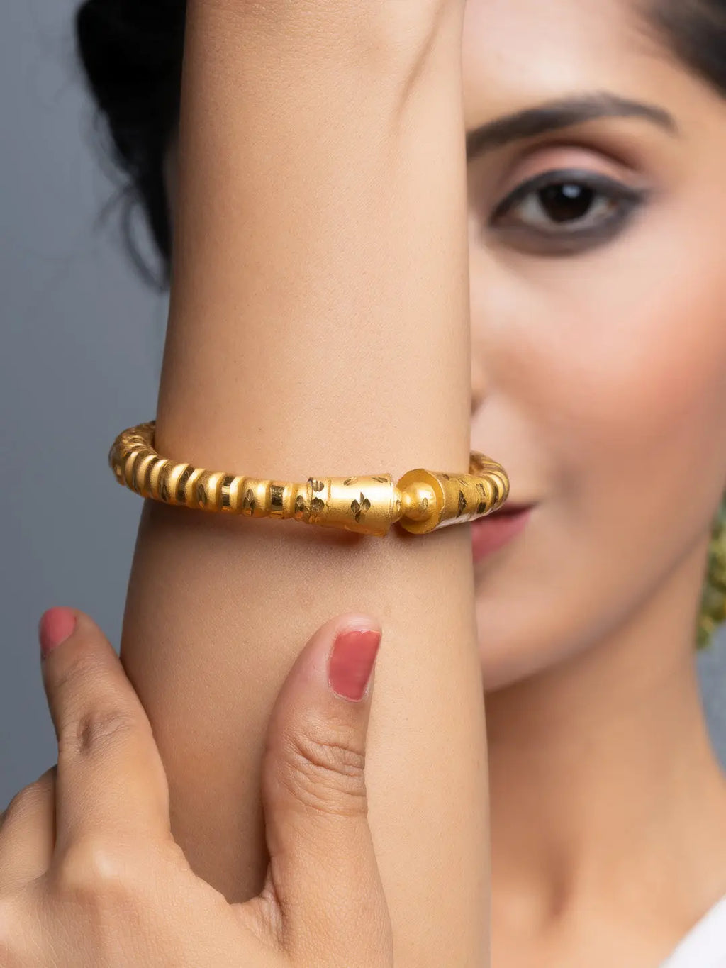 LOOK AND ADORN model wearing textured gold plated bangle on wrist close up showing polished finish