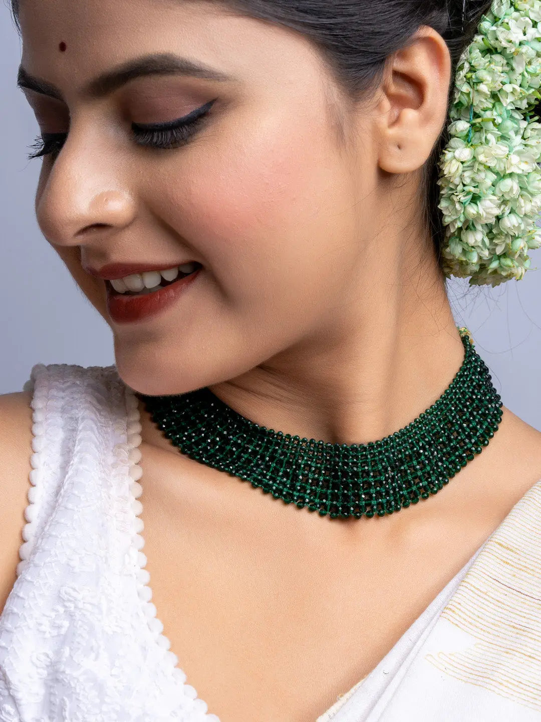 Handmade green crystal necklace worn by woman with traditional attire and floral hair accessory