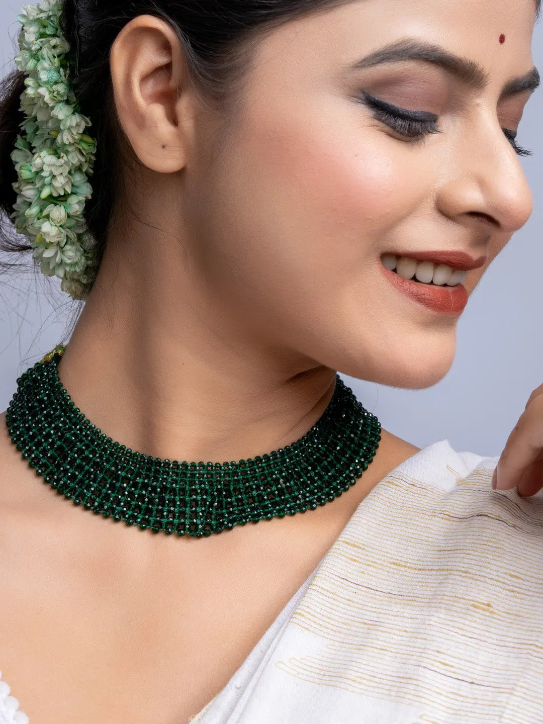 Handmade green crystal necklace worn by woman with traditional hairstyle and makeup
