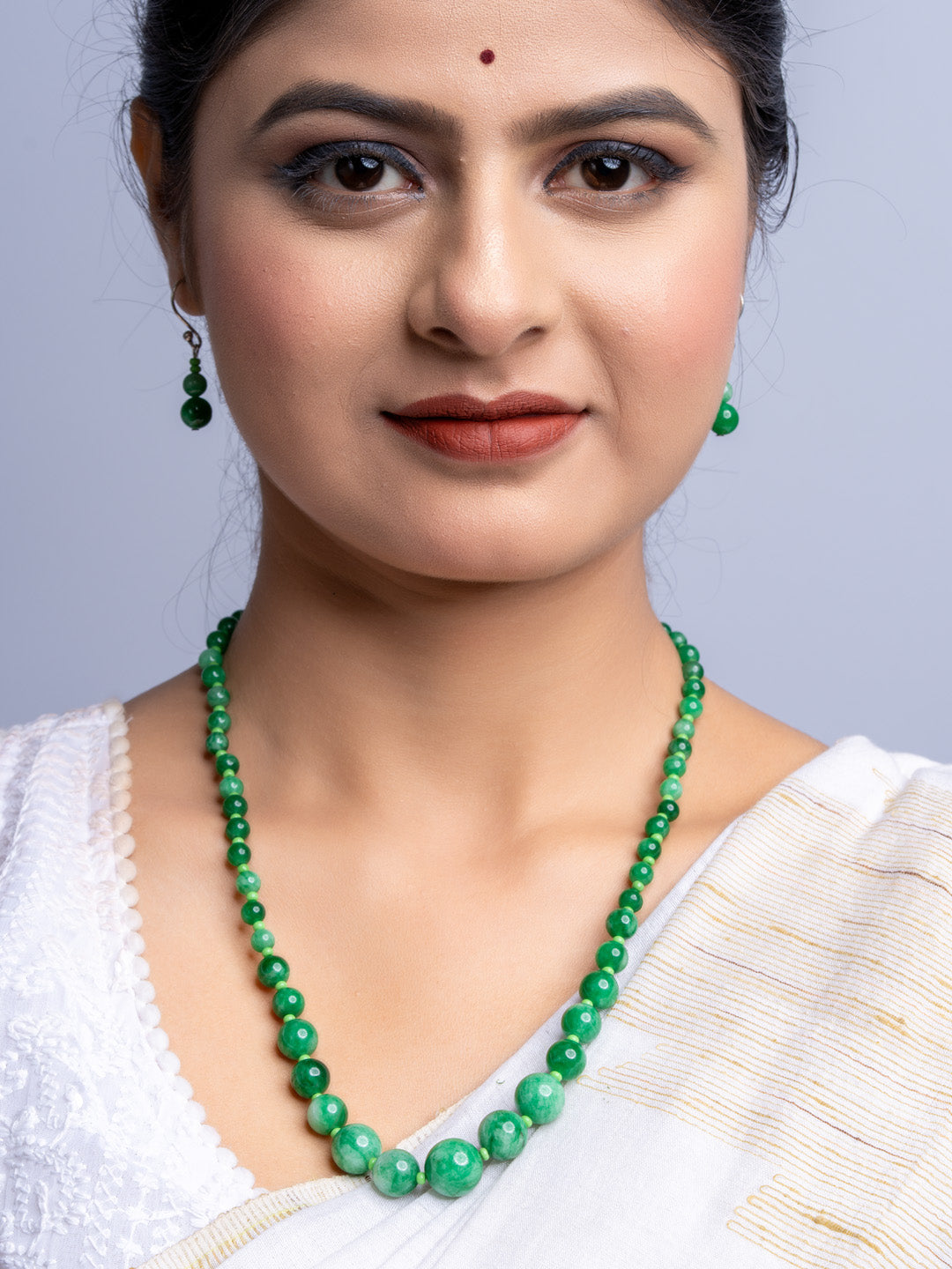 LOOK AND ADORN handmade green onyx necklace worn with matching earrings and white traditional outfit