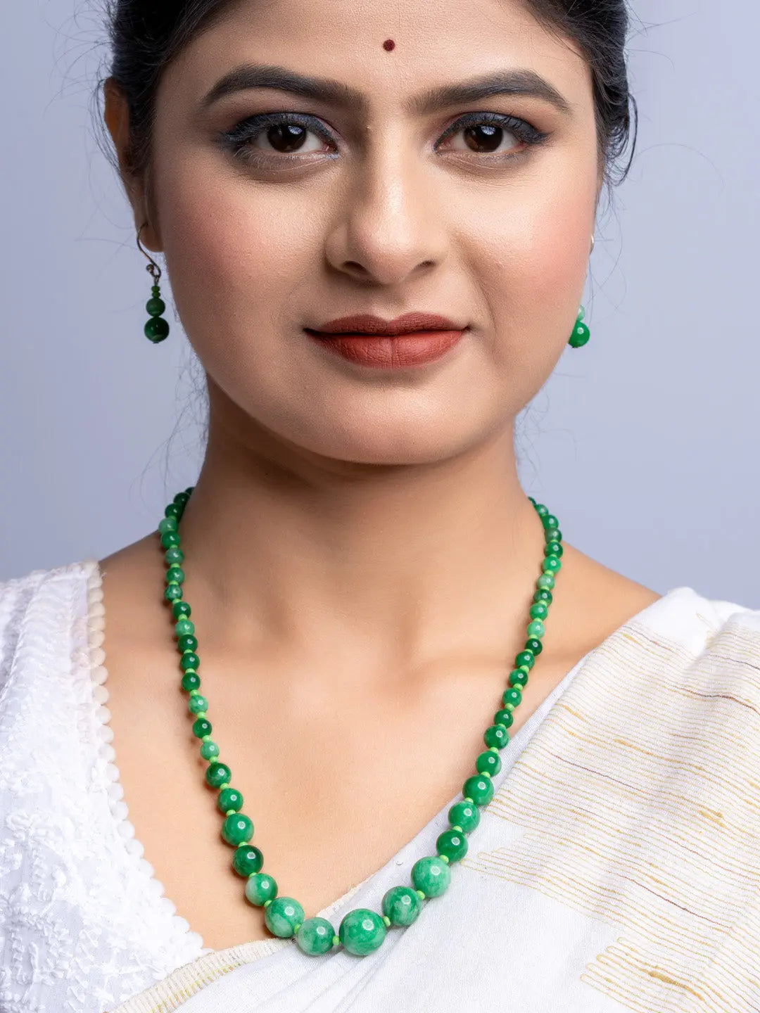 LOOK AND ADORN handmade green onyx necklace worn with matching earrings and white traditional outfit