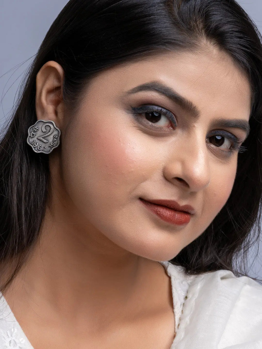 Close-up of woman wearing oxidised silver earrings with intricate design by LOOK AND ADORN