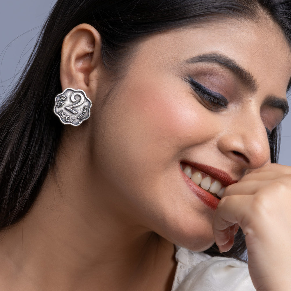 Close up of woman wearing oxidised silver earrings with intricate floral design by LOOK AND ADORN