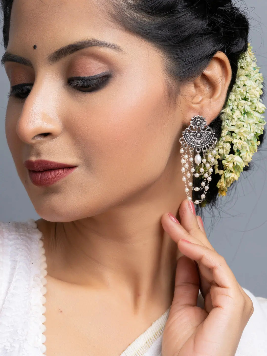LOOK AND ADORN handmade pearl stud earrings with intricate silver design worn by woman with traditional hairstyle