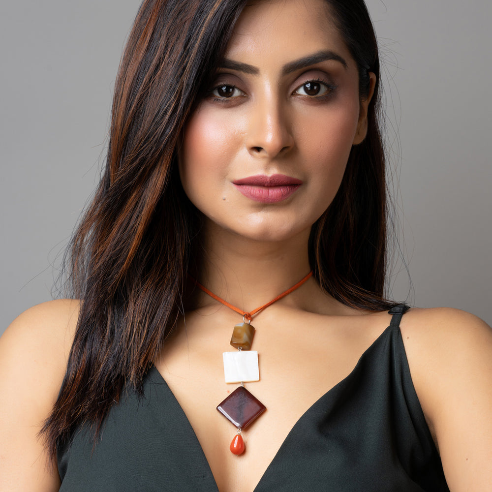 Woman wearing handmade mother of pearl necklace with geometric pendants by LOOK AND ADORN