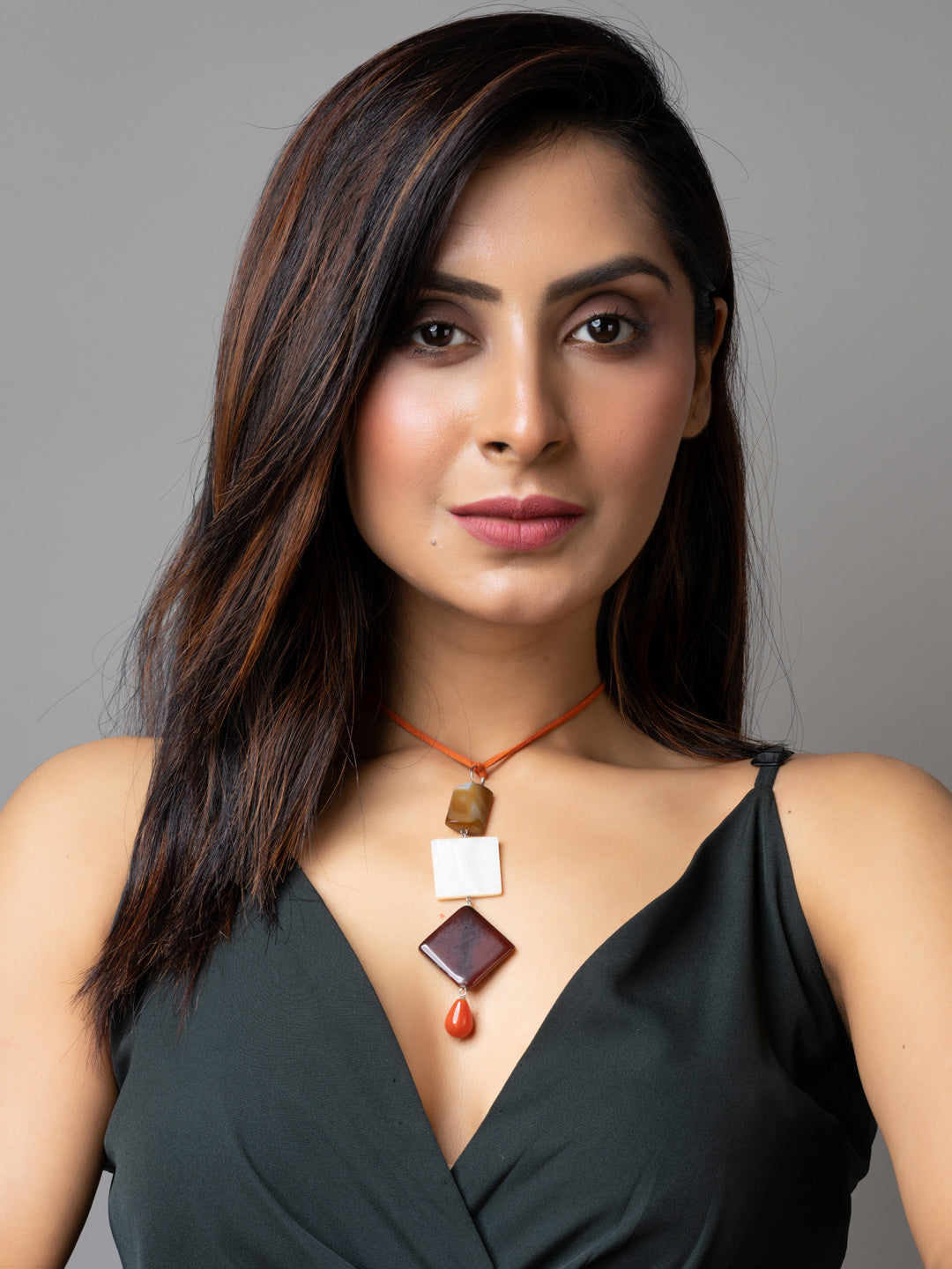 Woman wearing handmade mother of pearl necklace with geometric pendants by LOOK AND ADORN