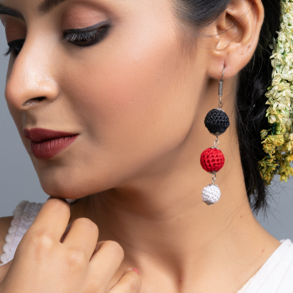 Close-up of woman wearing handmade Black Red Earrings with black, red, and white beads from LOOK AND ADORN