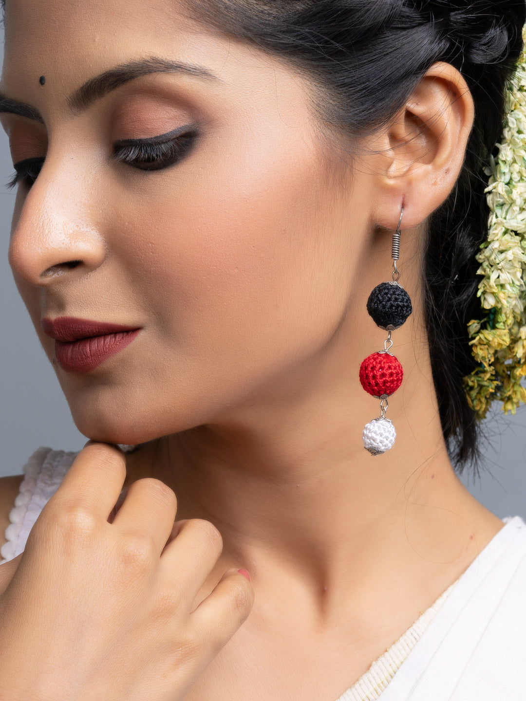 Close-up of woman wearing handmade Black Red Earrings with black, red, and white beads from LOOK AND ADORN