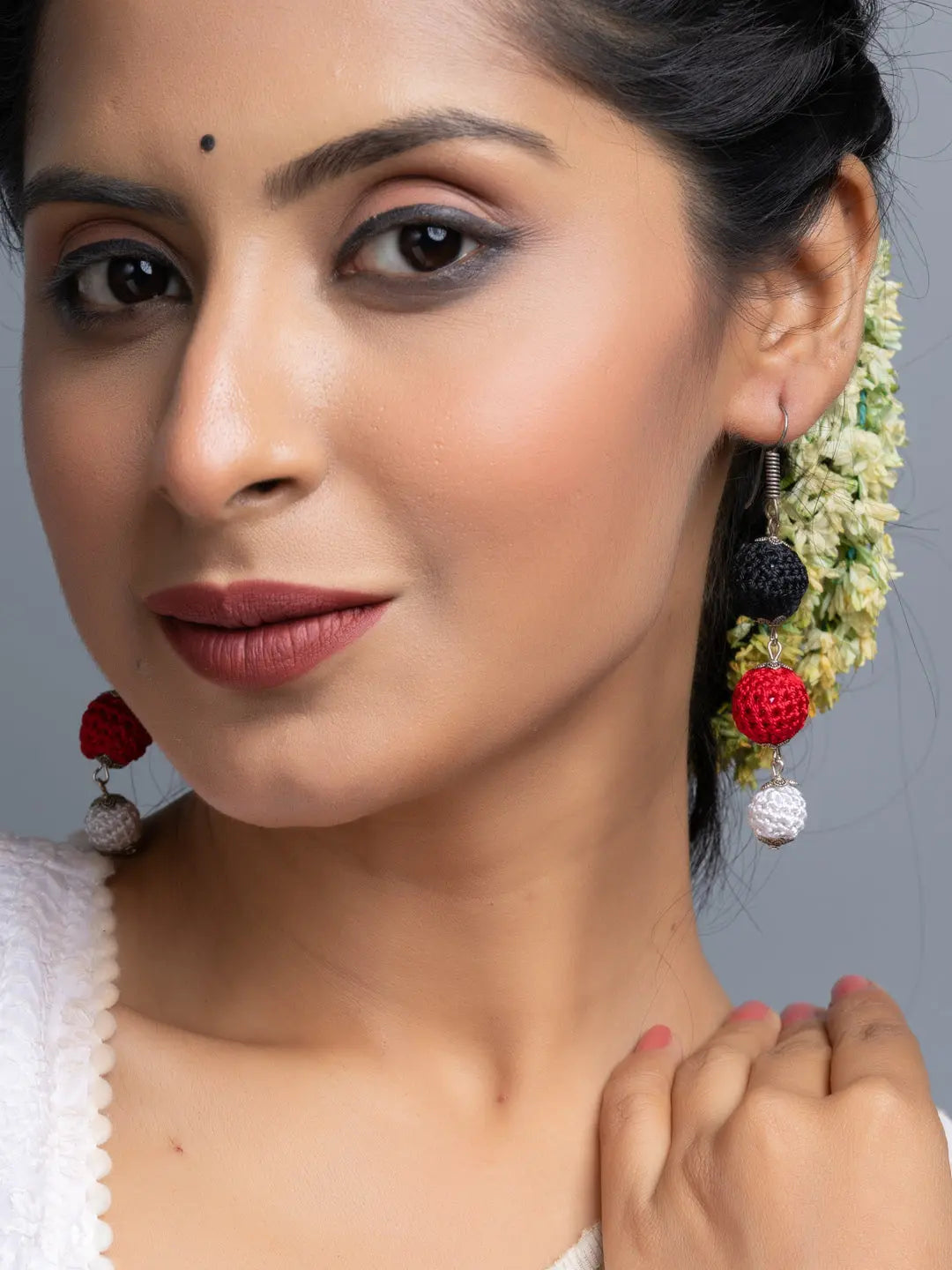 Close-up of woman wearing Handmade Black Red Earrings with crochet design by LOOK AND ADORN