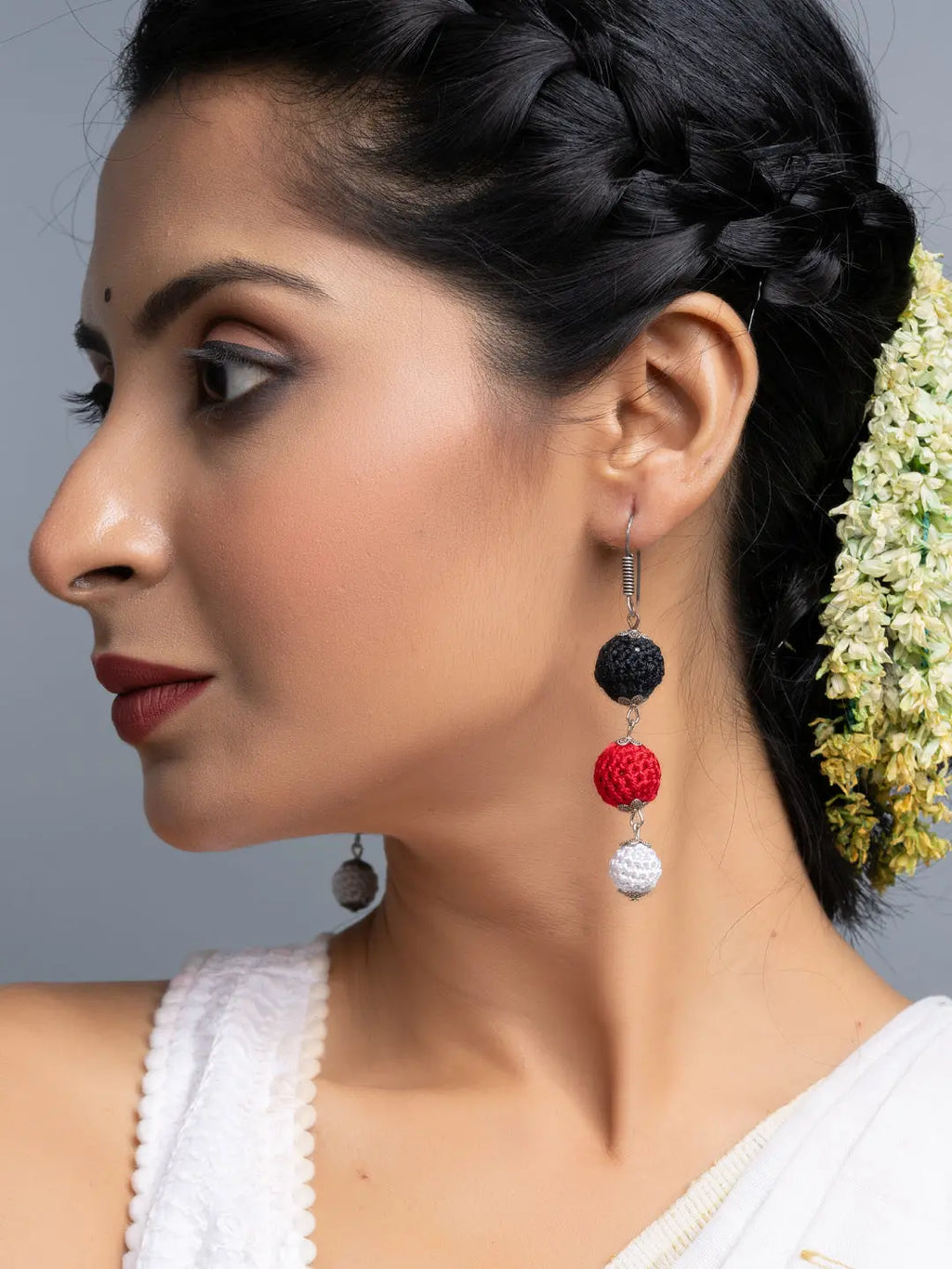 Handmade Black Red Earrings with three bead design worn by a woman with braided hair and traditional attire