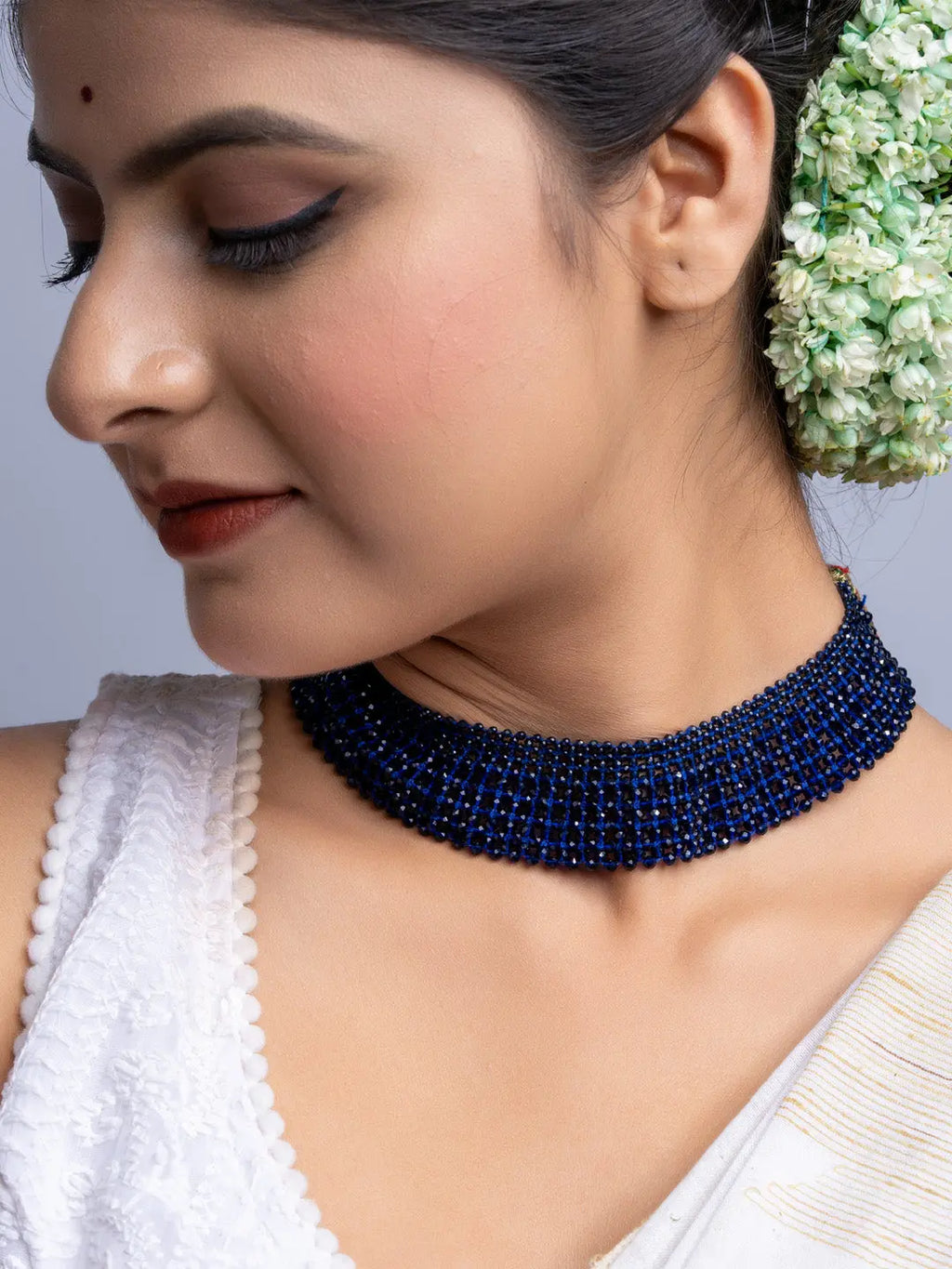 Handmade blue crystal necklace from LOOK AND ADORN worn by woman with floral hair accessory