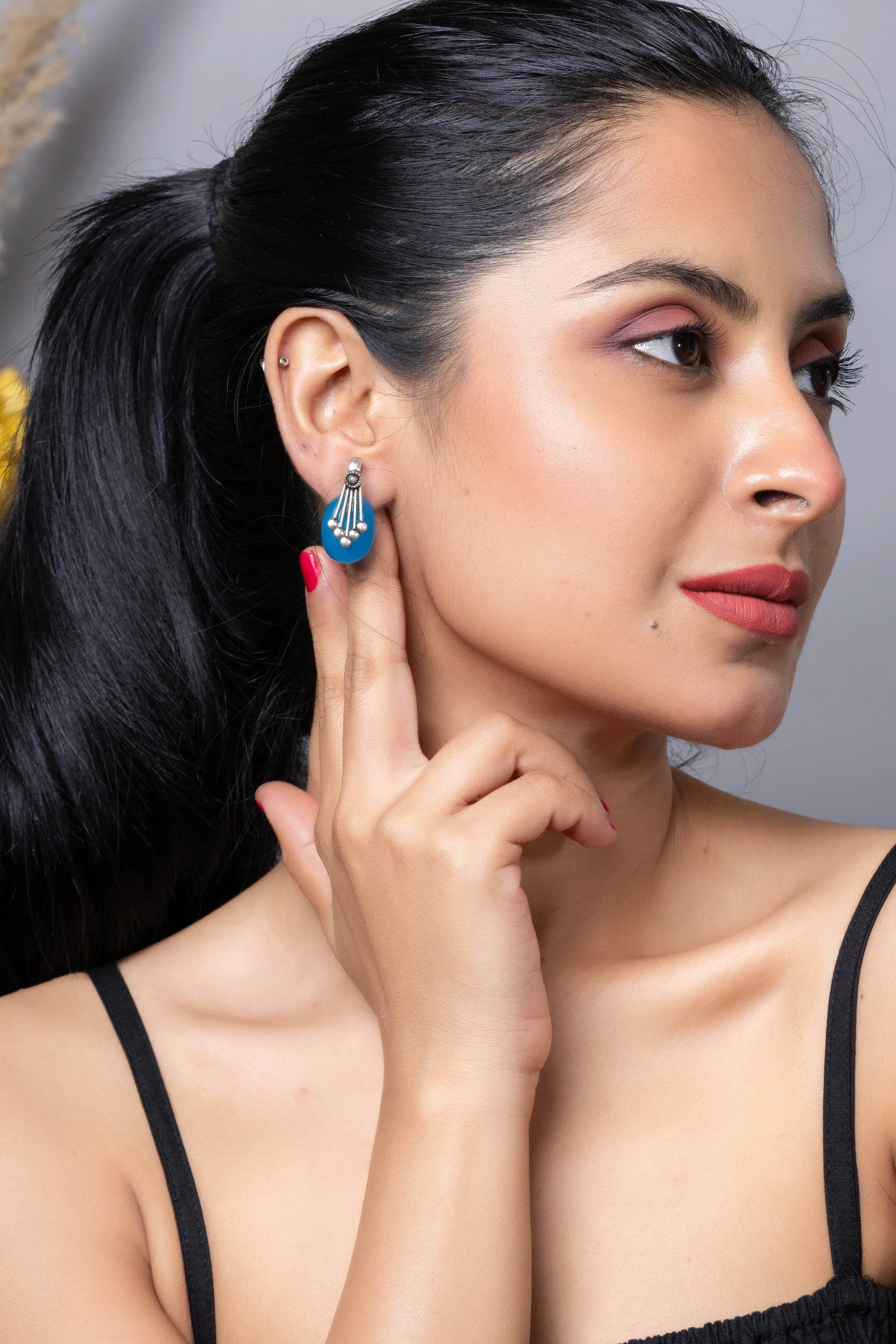 Oxidised silver blue stone stud earring displayed on model, showcasing elegant design