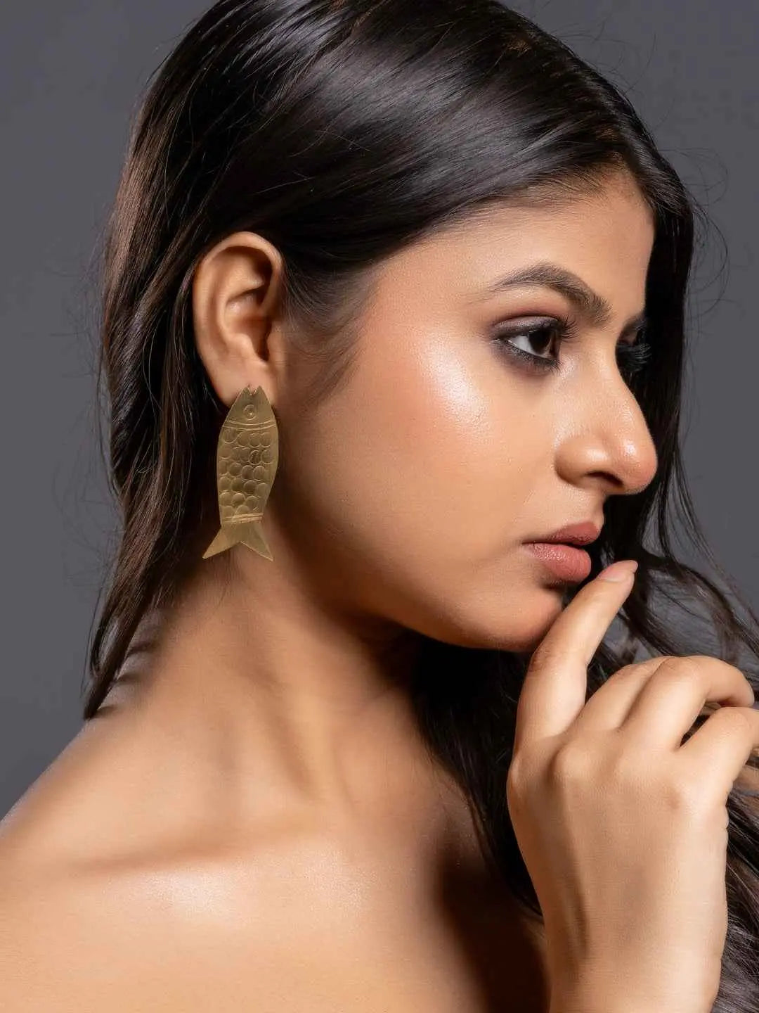 Elegant brass earrings shaped like fish with a polished finish, showcasing unique artisan design