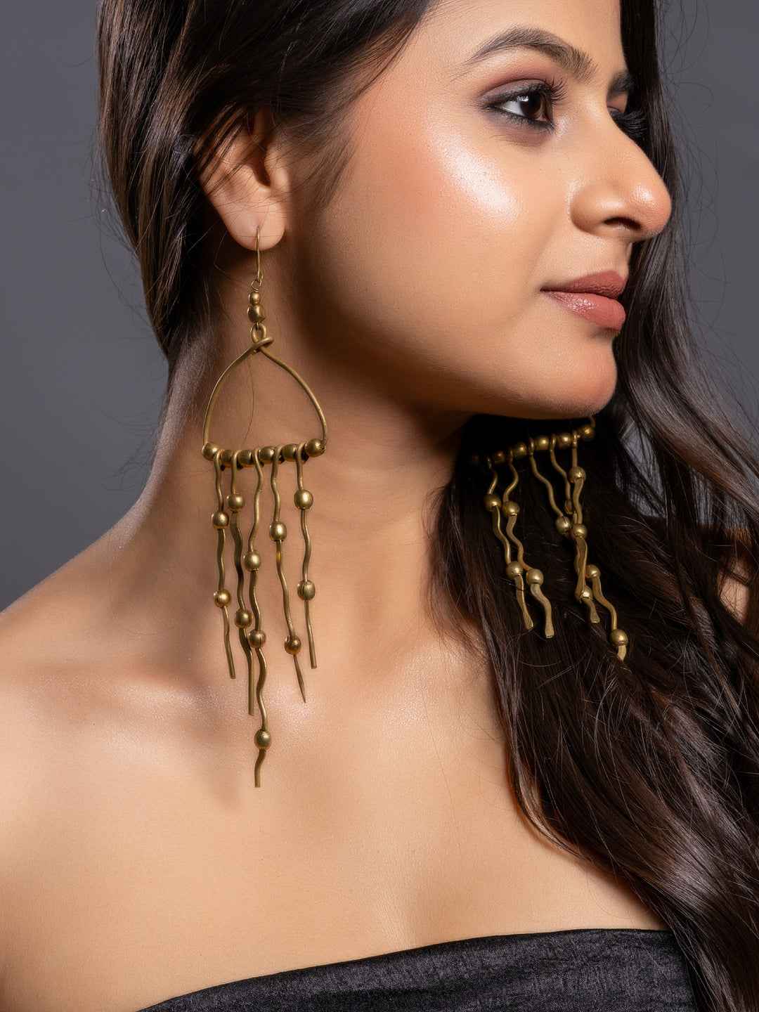 Stylish brass earrings with long dangling designs and bead accents, perfect for a trendy look