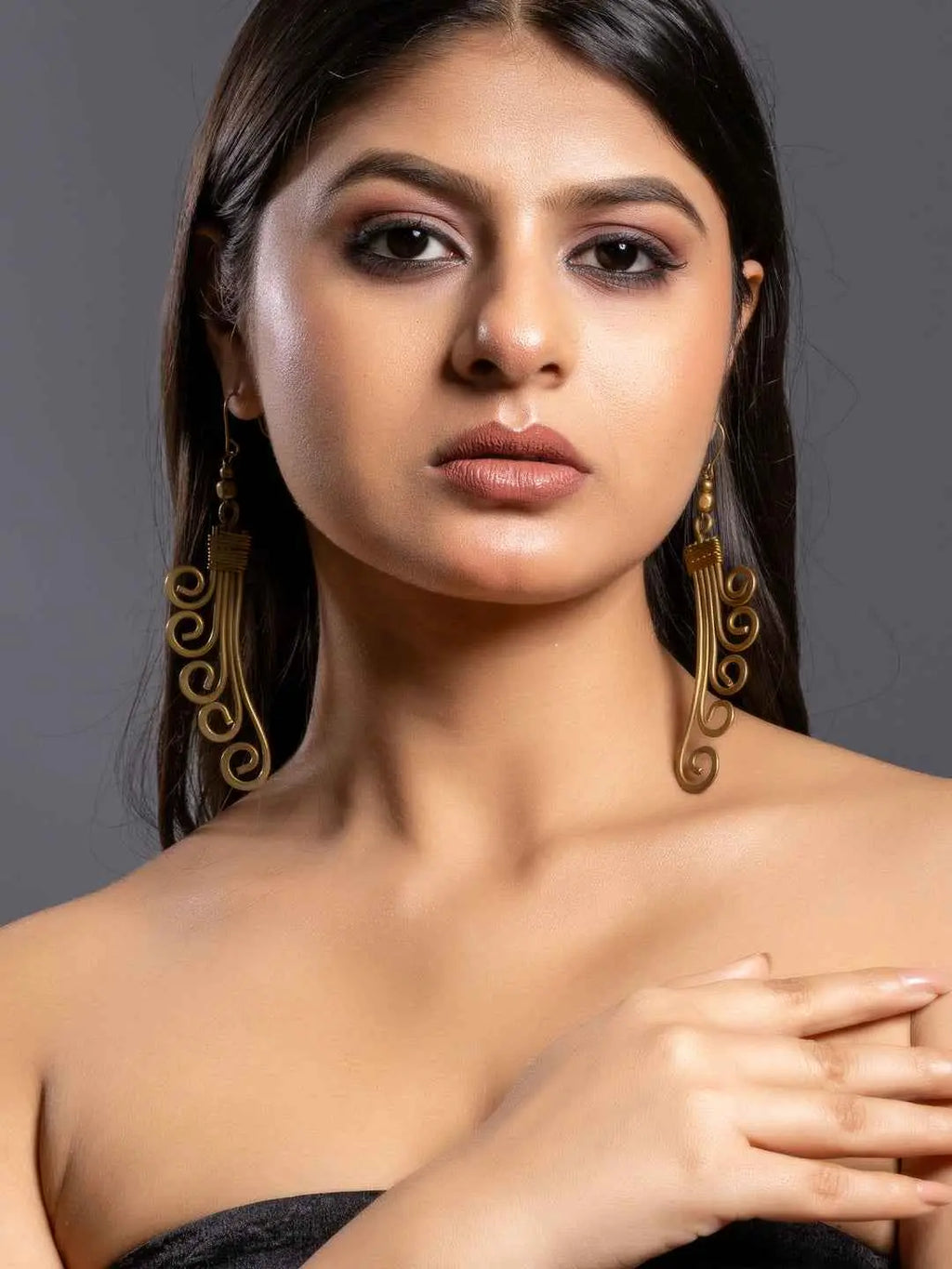Dokra brass earrings with intricate swirling patterns and a vintage-inspired design
