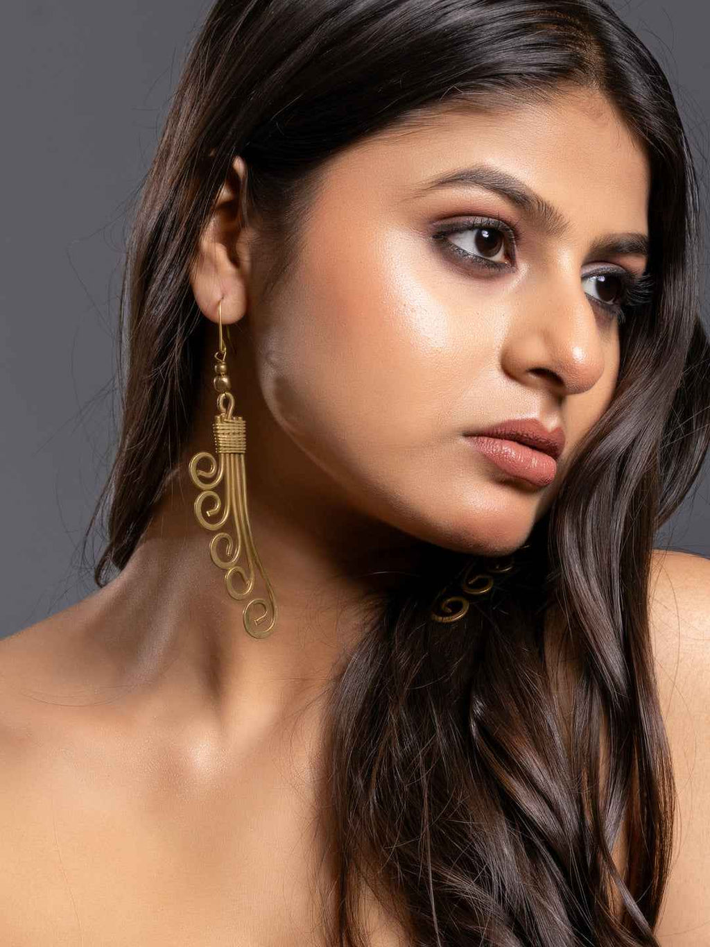 Dokra brass earrings in gold tone with intricate swirling design, perfect for a stylish look