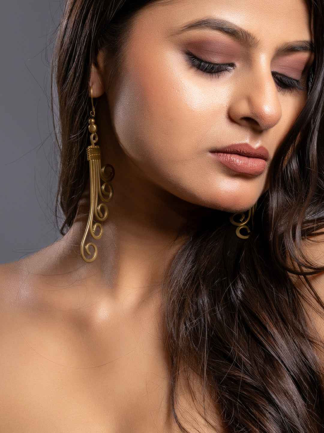 Elegant Dokra jewellery brass earrings with intricate swirl design, crafted with a vintage charm