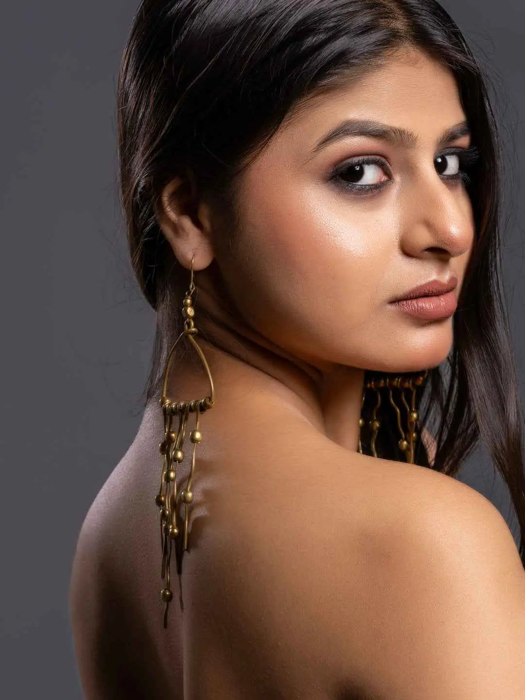 Dokra jewellery brass earrings with intricate design and dangling details in gold-tone finish