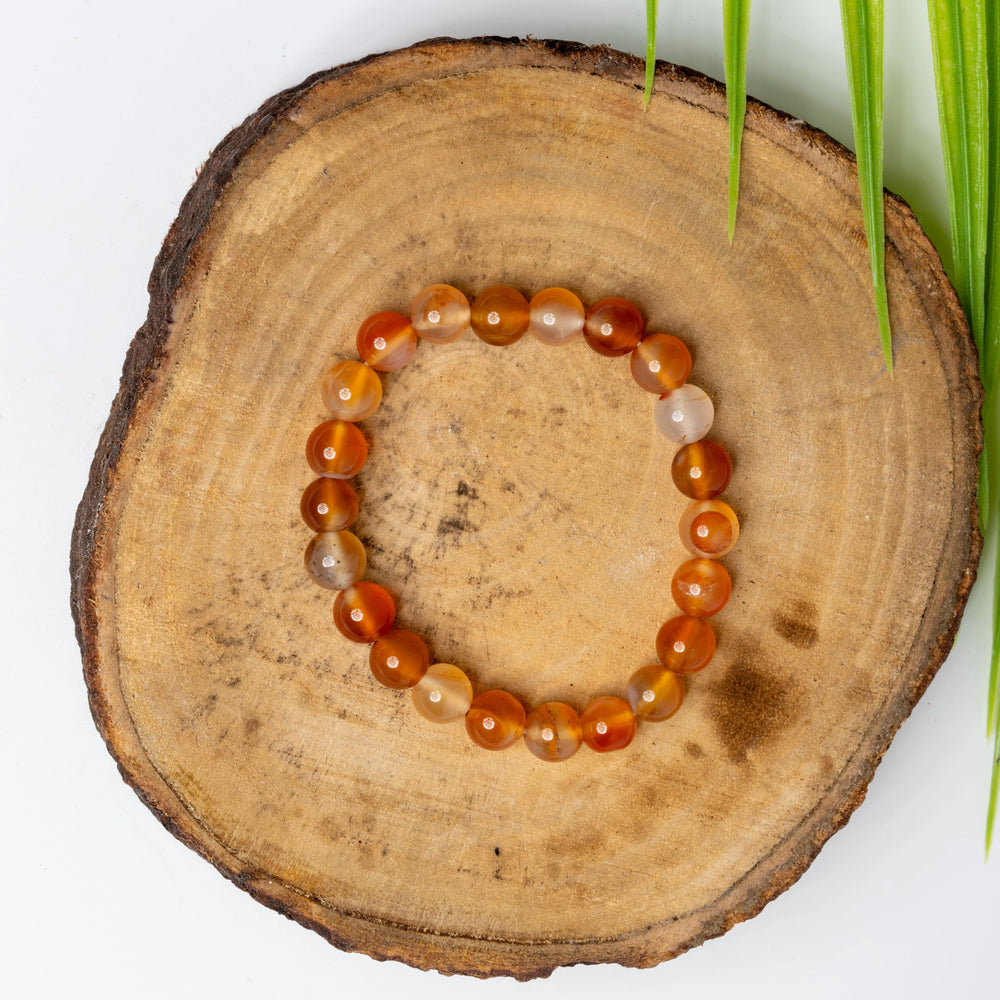 Carnelian bracelet with polished beads on a natural wooden surface, perfect for boho jewelry lovers