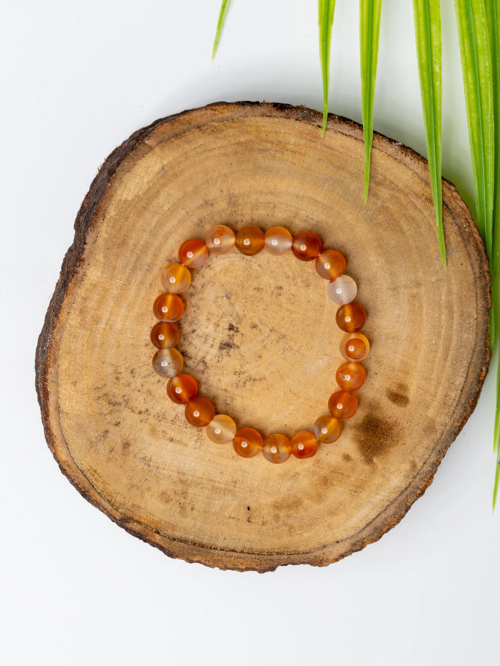 Carnelian bracelet with polished beads on a natural wooden surface, perfect for boho jewelry lovers
