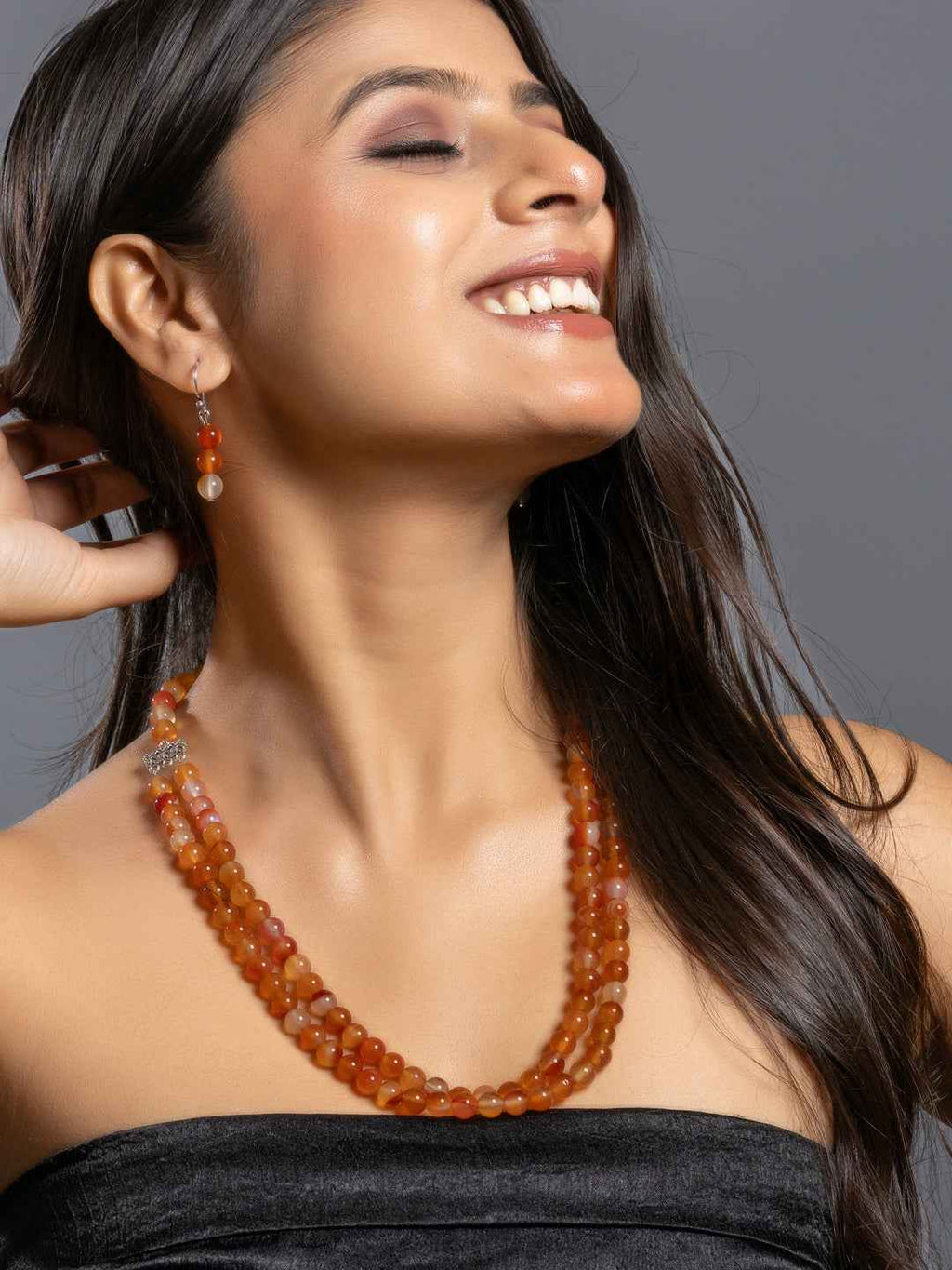 Handmade carnelian necklace set with layered orange beads and matching earrings, perfect for a stylish look.