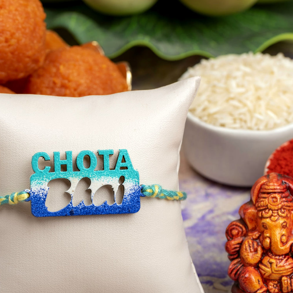 LOOK AND ADORN chhota bhai rakhi in blue with decorative background including sweets and Ganesh idol
