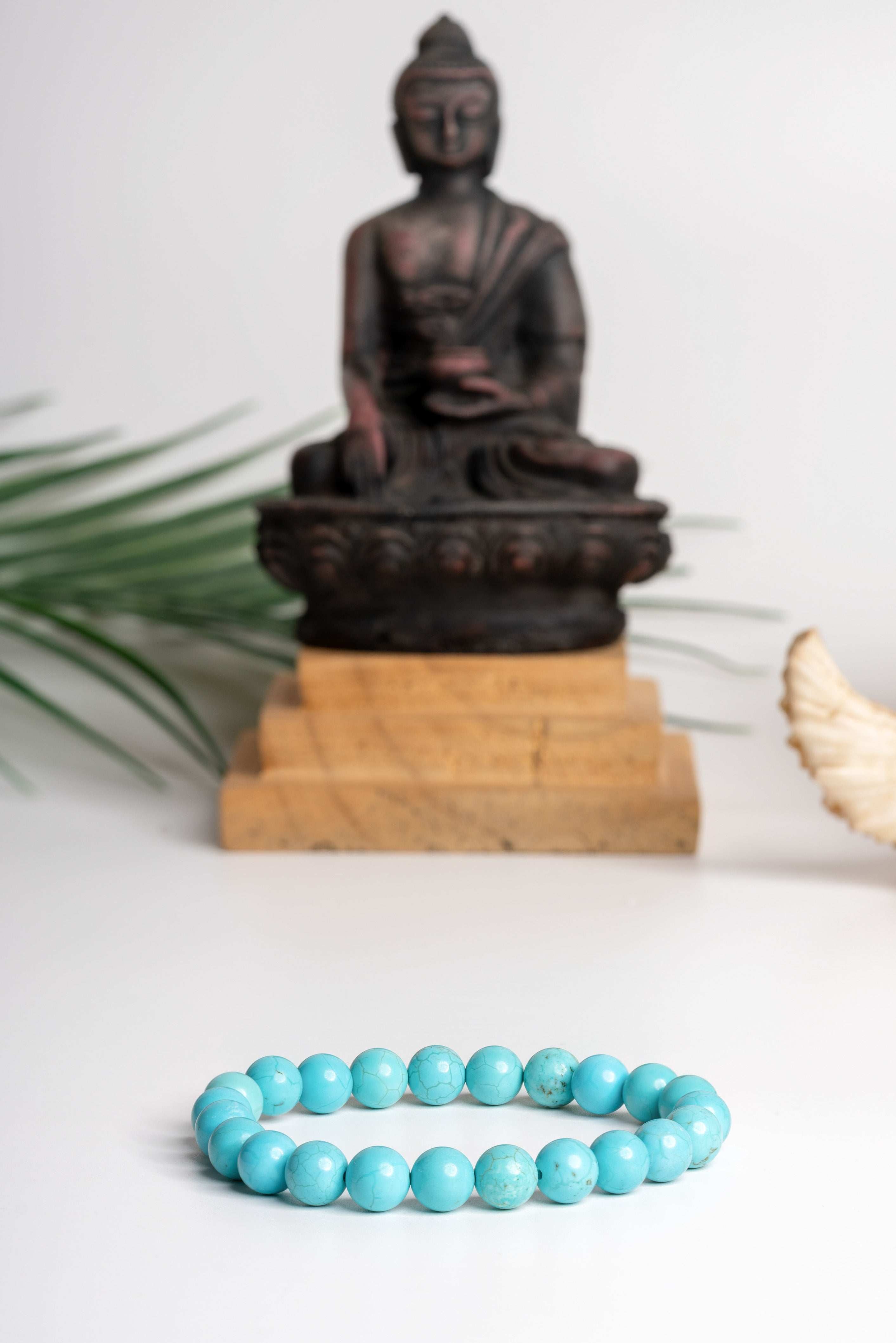 Firoza stone bracelet featuring smooth turquoise beads set against a serene Buddha background