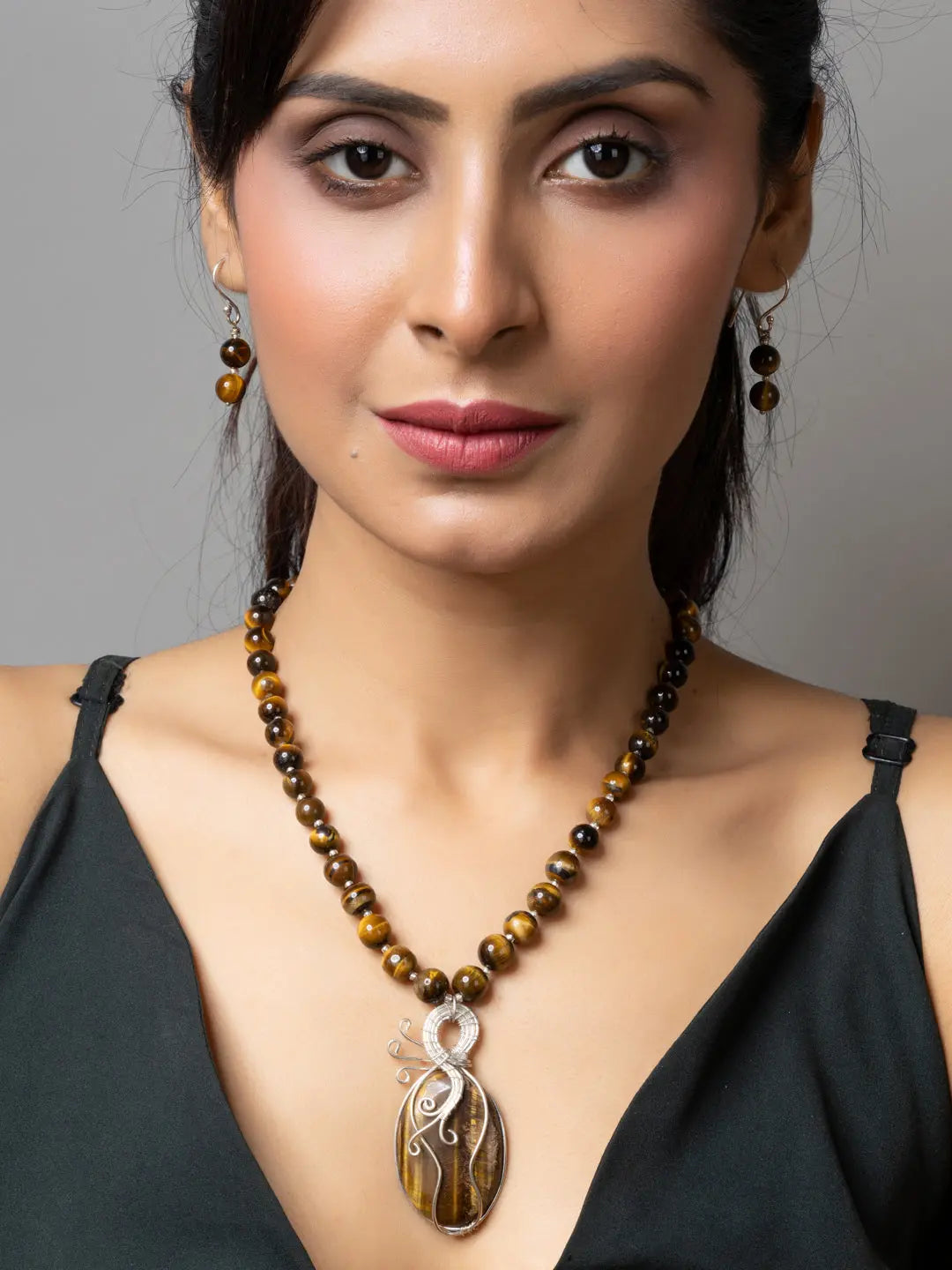 Woman wearing a handmade tiger eye necklace with matching earrings by LOOK AND ADORN