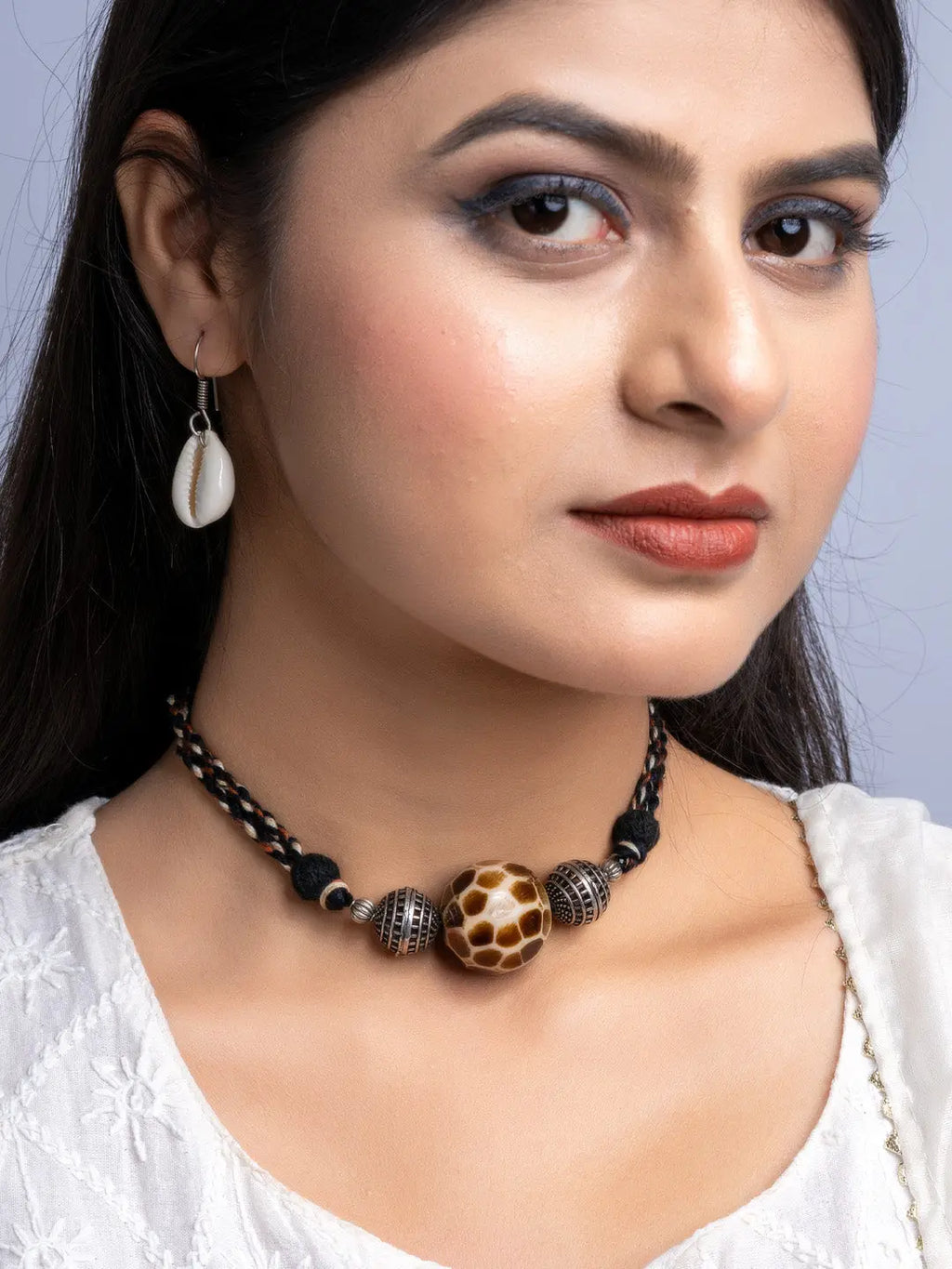 Handmade german silver choker set with black and patterned beads worn by woman in white top