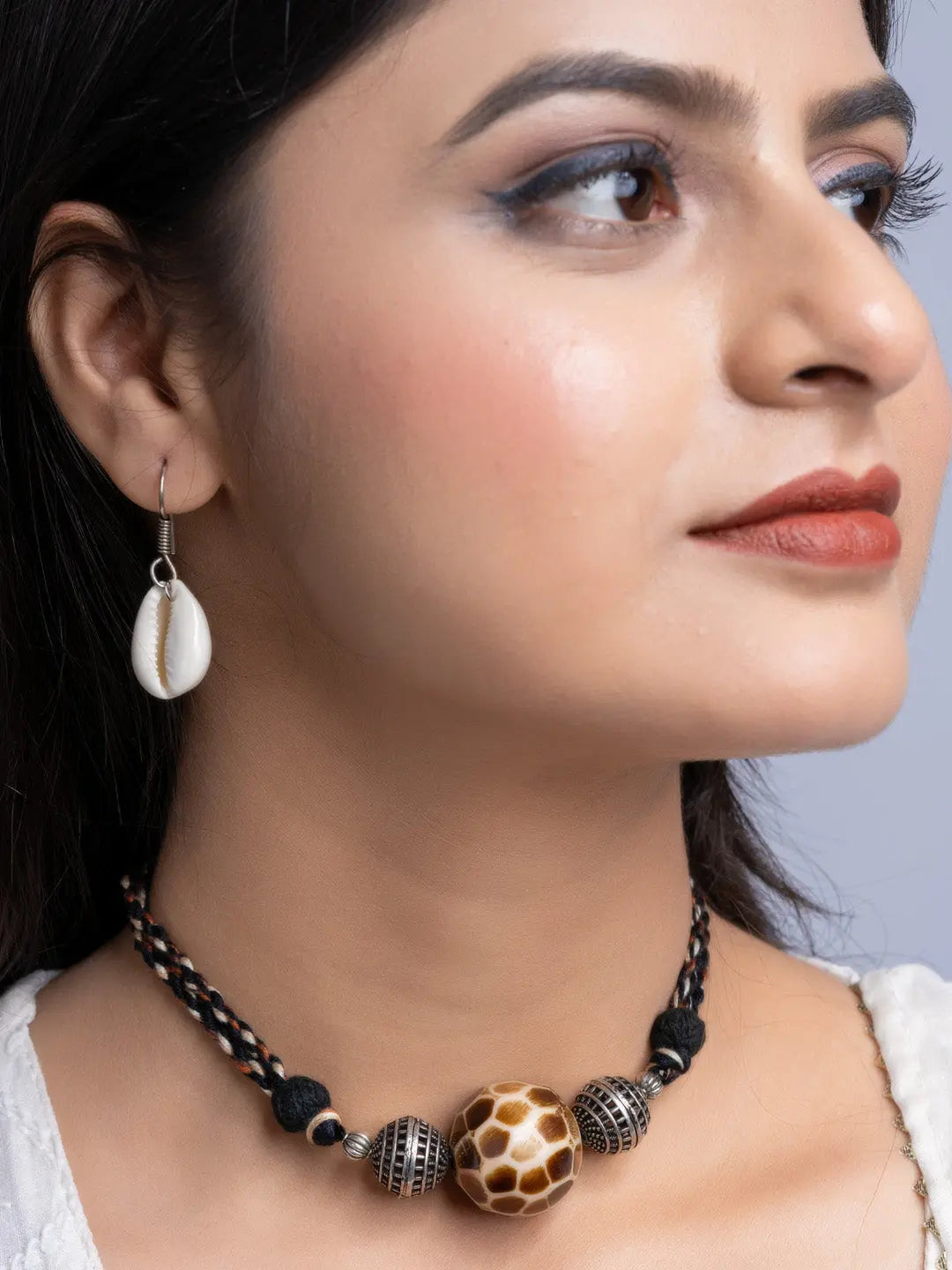 Handmade german silver choker set with black braided cord and patterned beads worn by woman