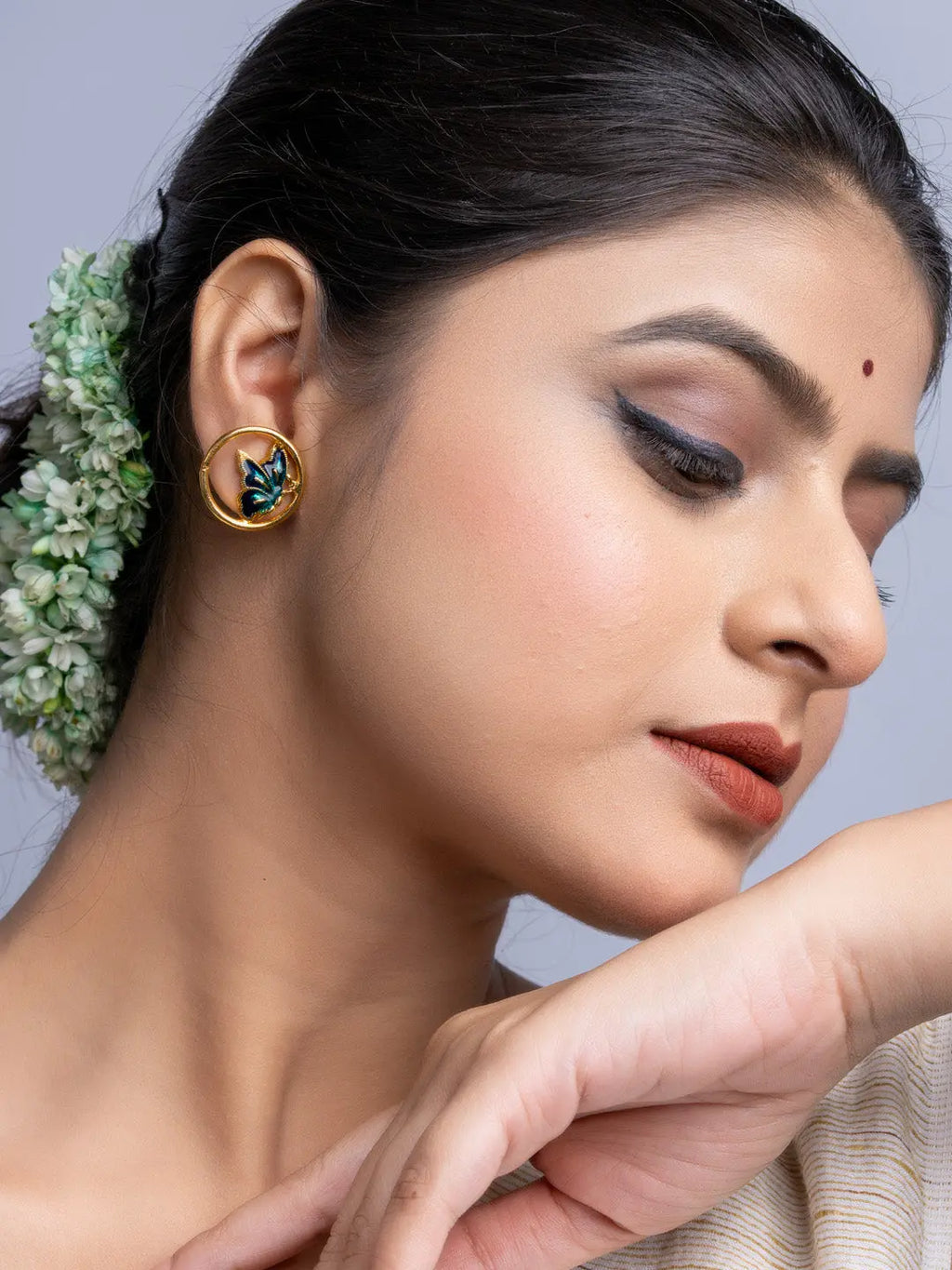 Close-up of woman wearing LOOK AND ADORN gold plated earrings with floral design and makeup