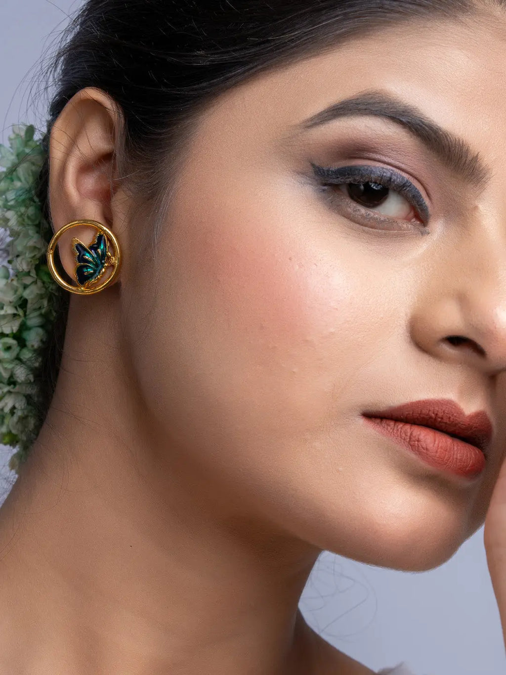 Close-up of woman wearing LOOK AND ADORN gold plated earrings with butterfly design