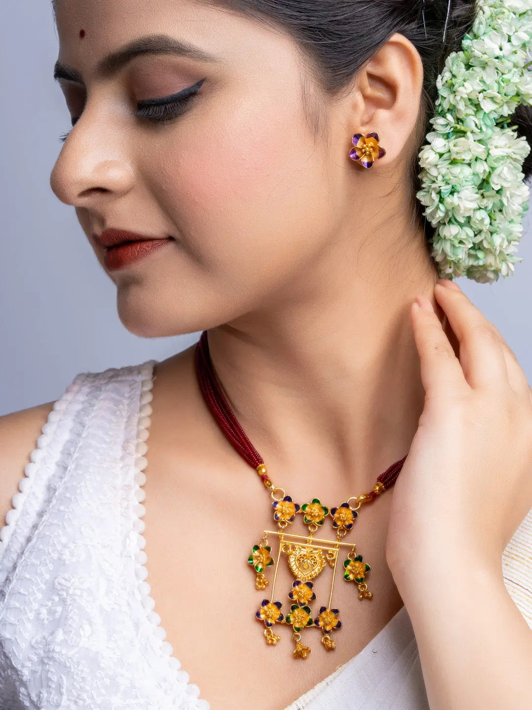LOOK AND ADORN gold plated necklace and floral earrings set worn by woman with traditional hairstyle and white outfit