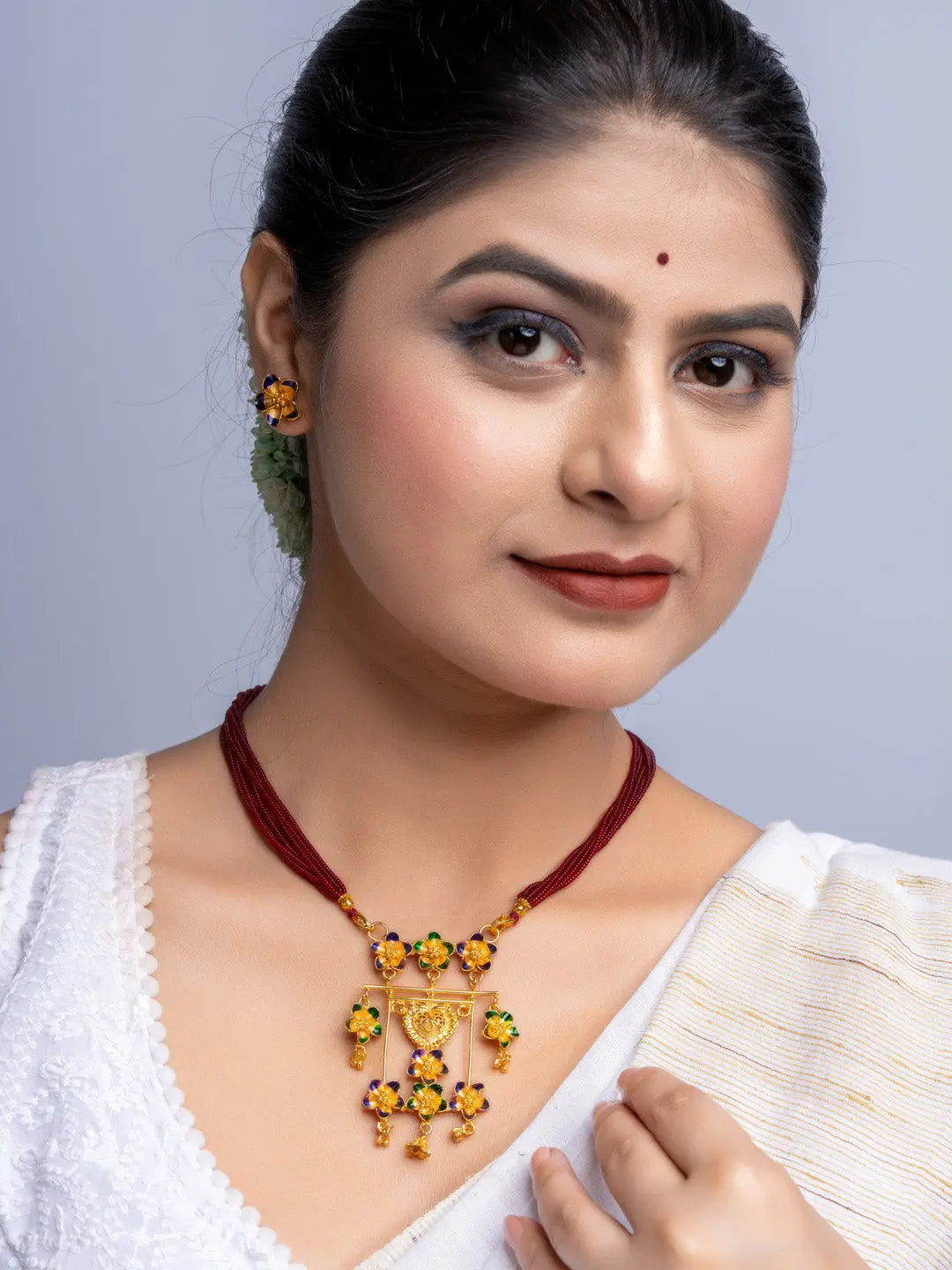 Woman wearing gold plated floral necklace and matching earrings from LOOK AND ADORN