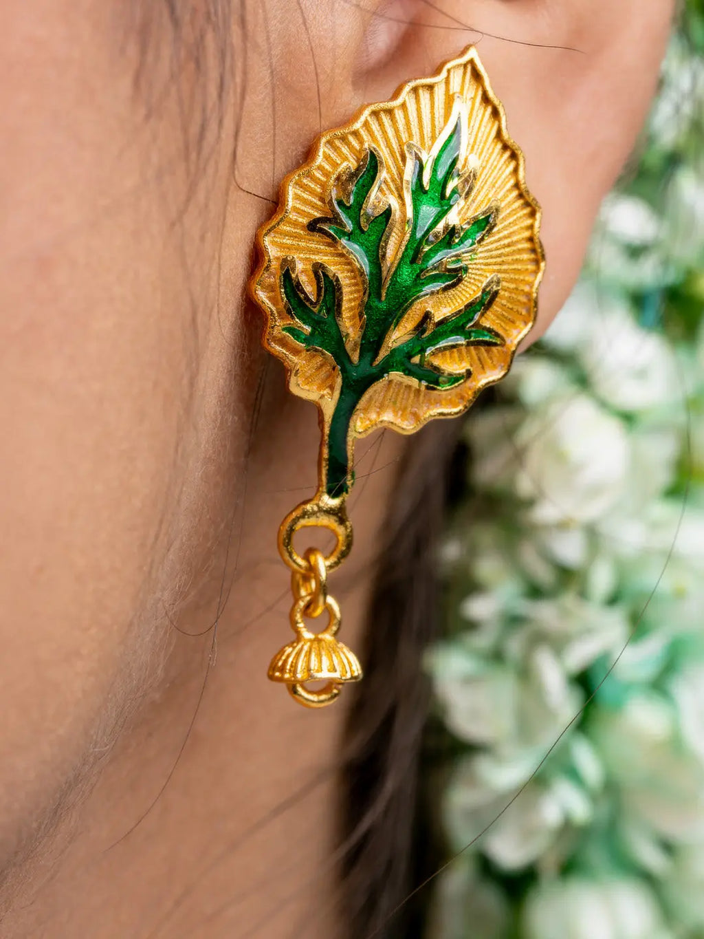 Gold plated leaf-shaped earring with green enamel detailing and small dangling charm by LOOK AND ADORN