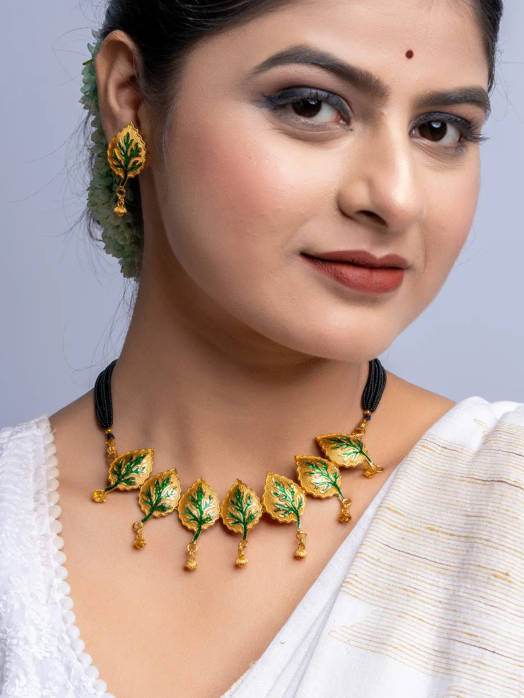 LOOK AND ADORN gold plated green leaf design necklace and matching earrings on woman
