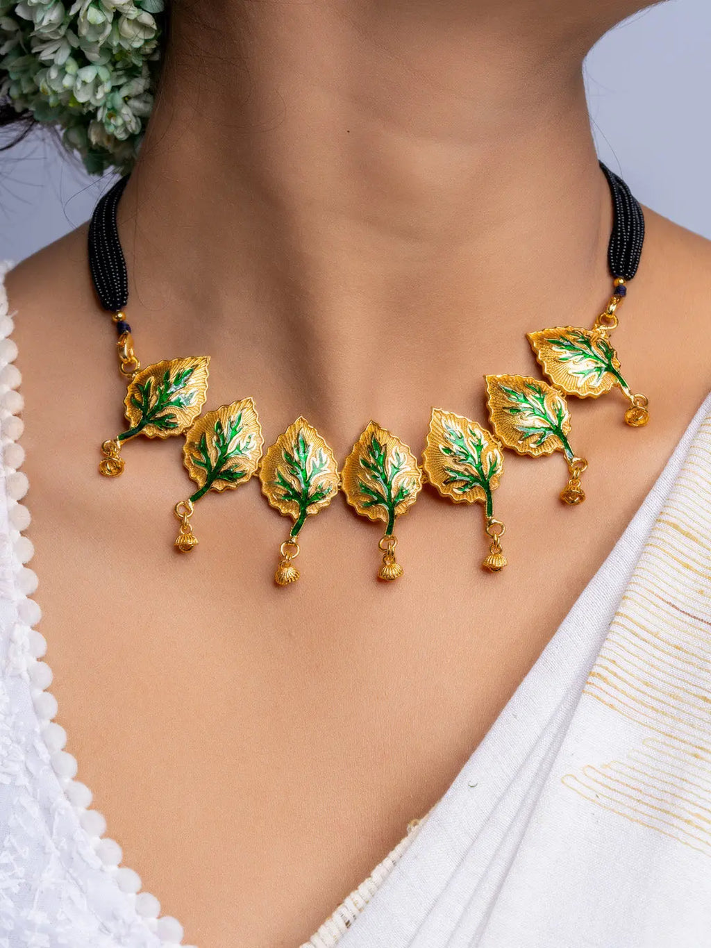 LOOK AND ADORN gold plated necklace with green enamel leaf design on black beaded chain