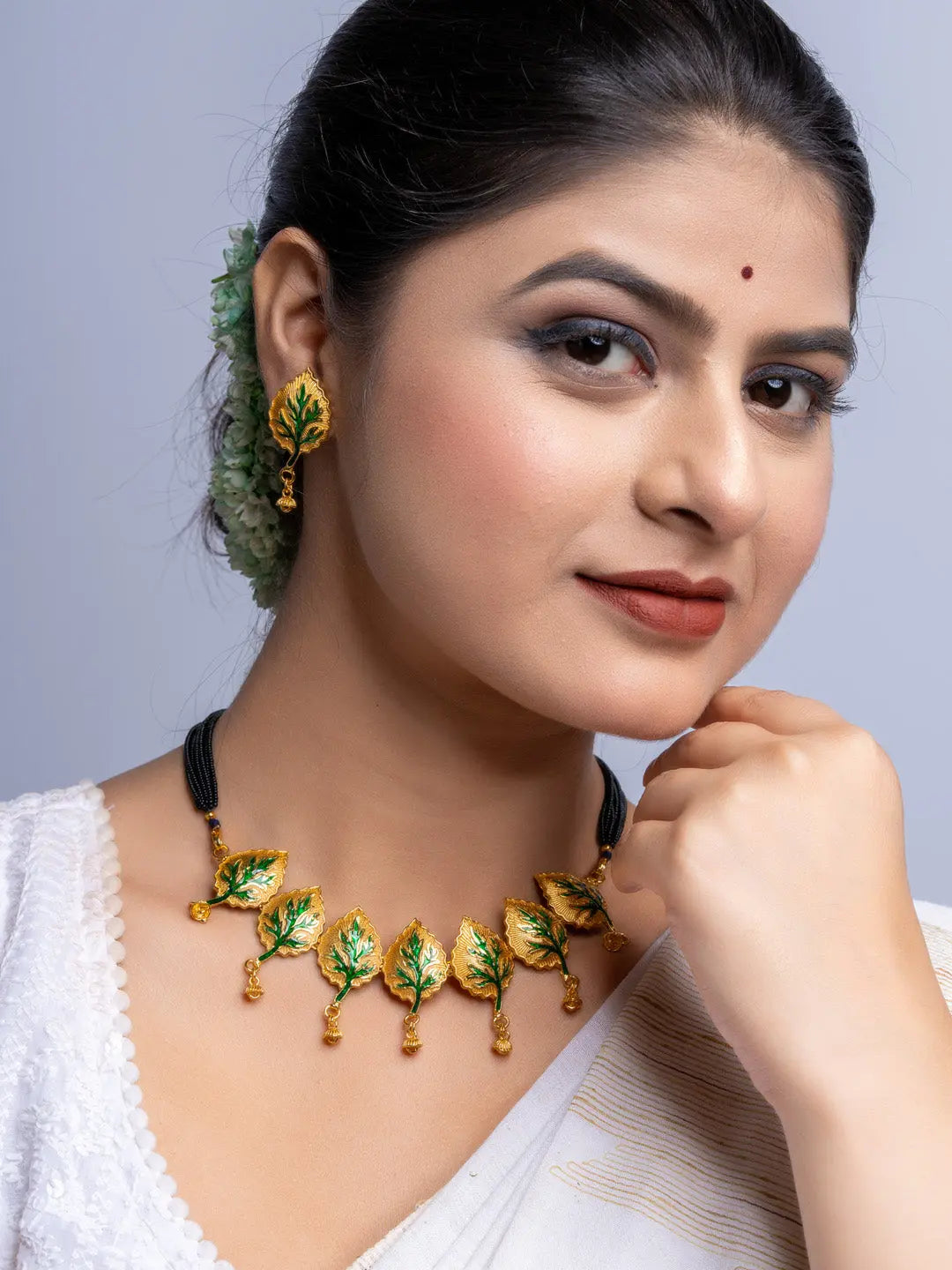 Woman wearing LOOK AND ADORN gold plated leaf design necklace and matching earrings with traditional attire