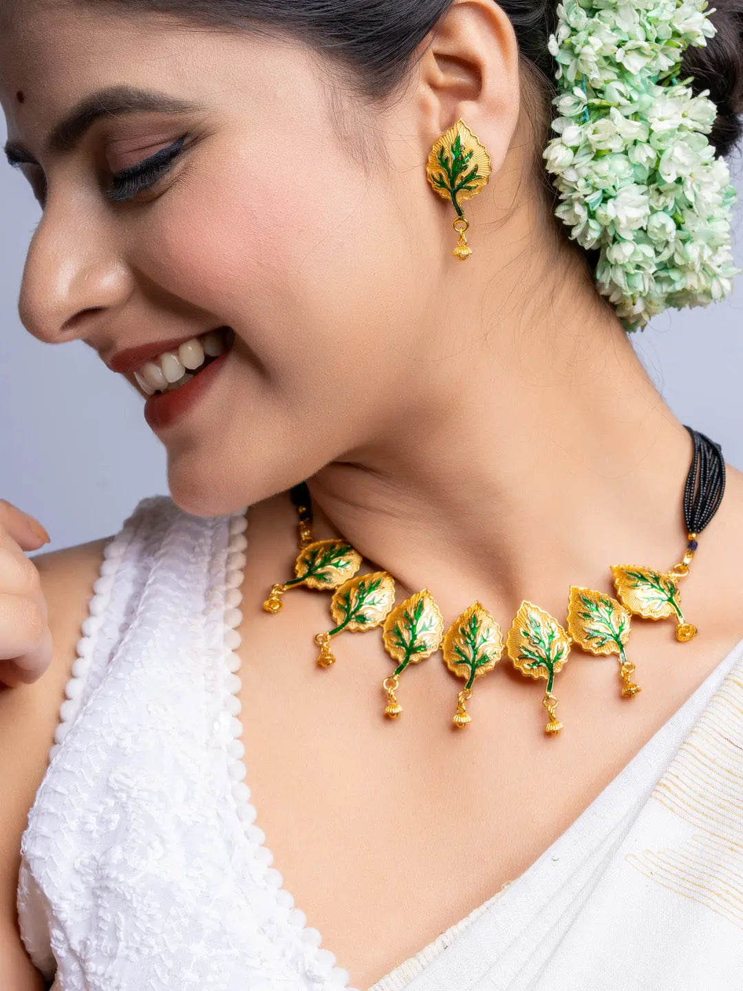 LOOK AND ADORN gold plated leaf design necklace and matching earrings worn with traditional white attire