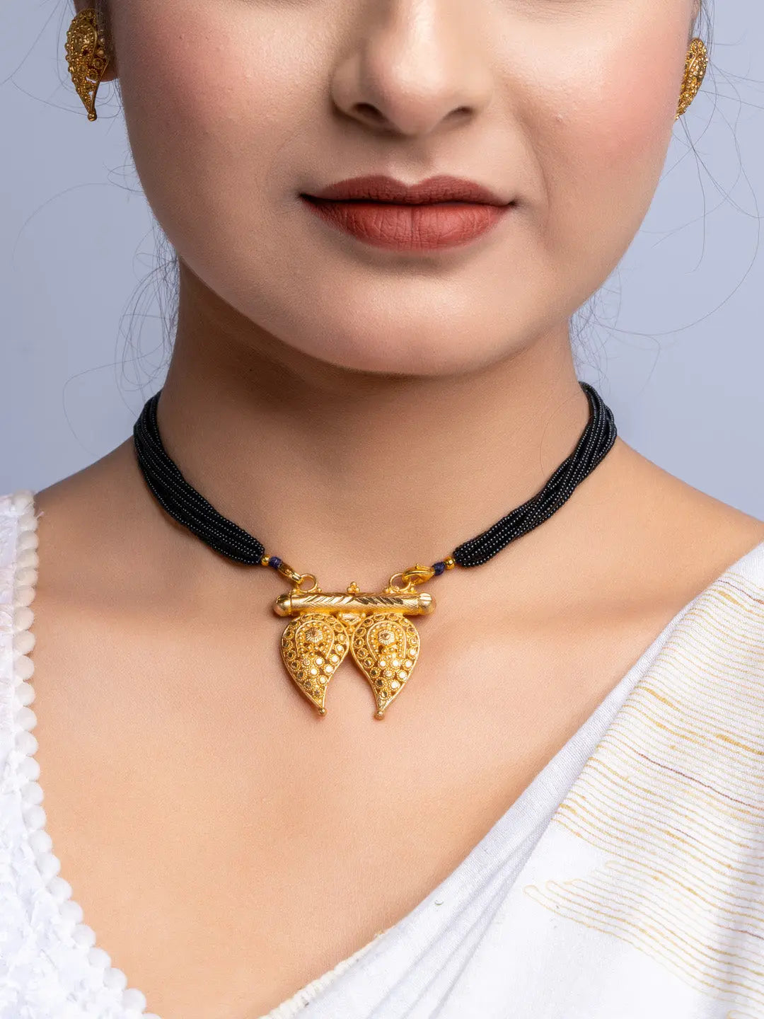 LOOK AND ADORN gold plated necklace with black beads and intricate leaf pendant on model