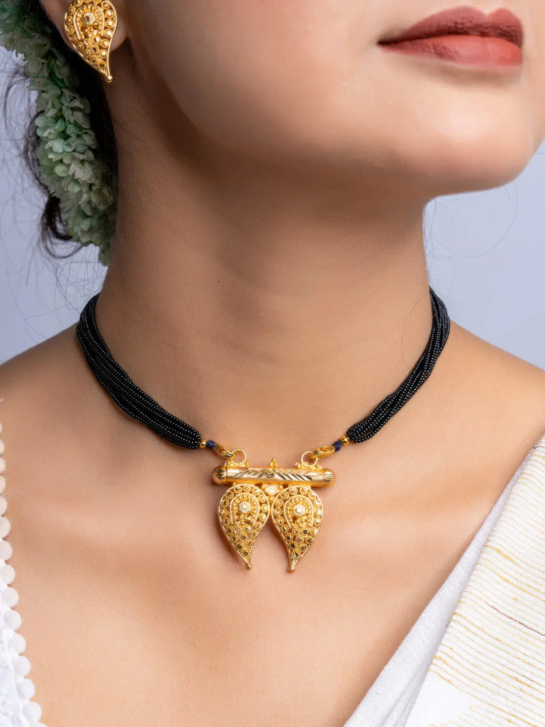 LOOK AND ADORN gold plated necklace with black beaded chain and intricate pendant design worn on neck