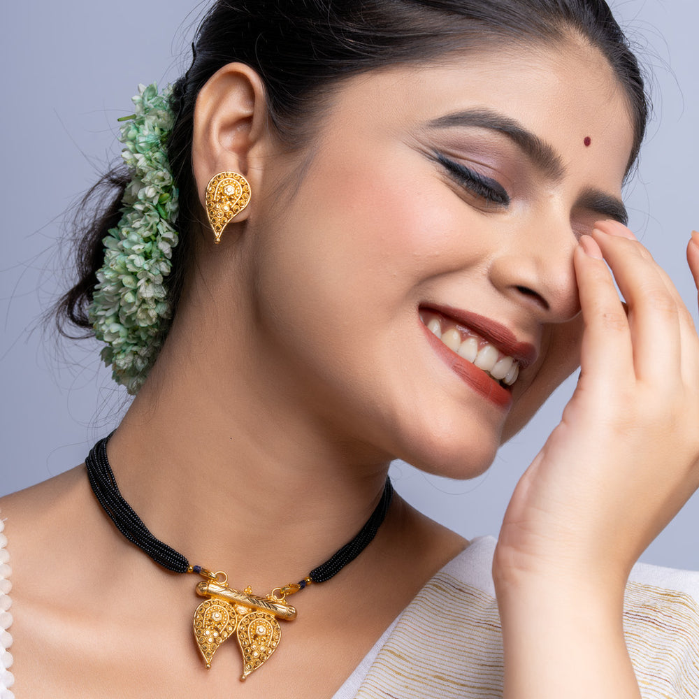 LOOK AND ADORN gold plated intricate necklace and matching earrings worn by smiling woman with traditional hairstyle