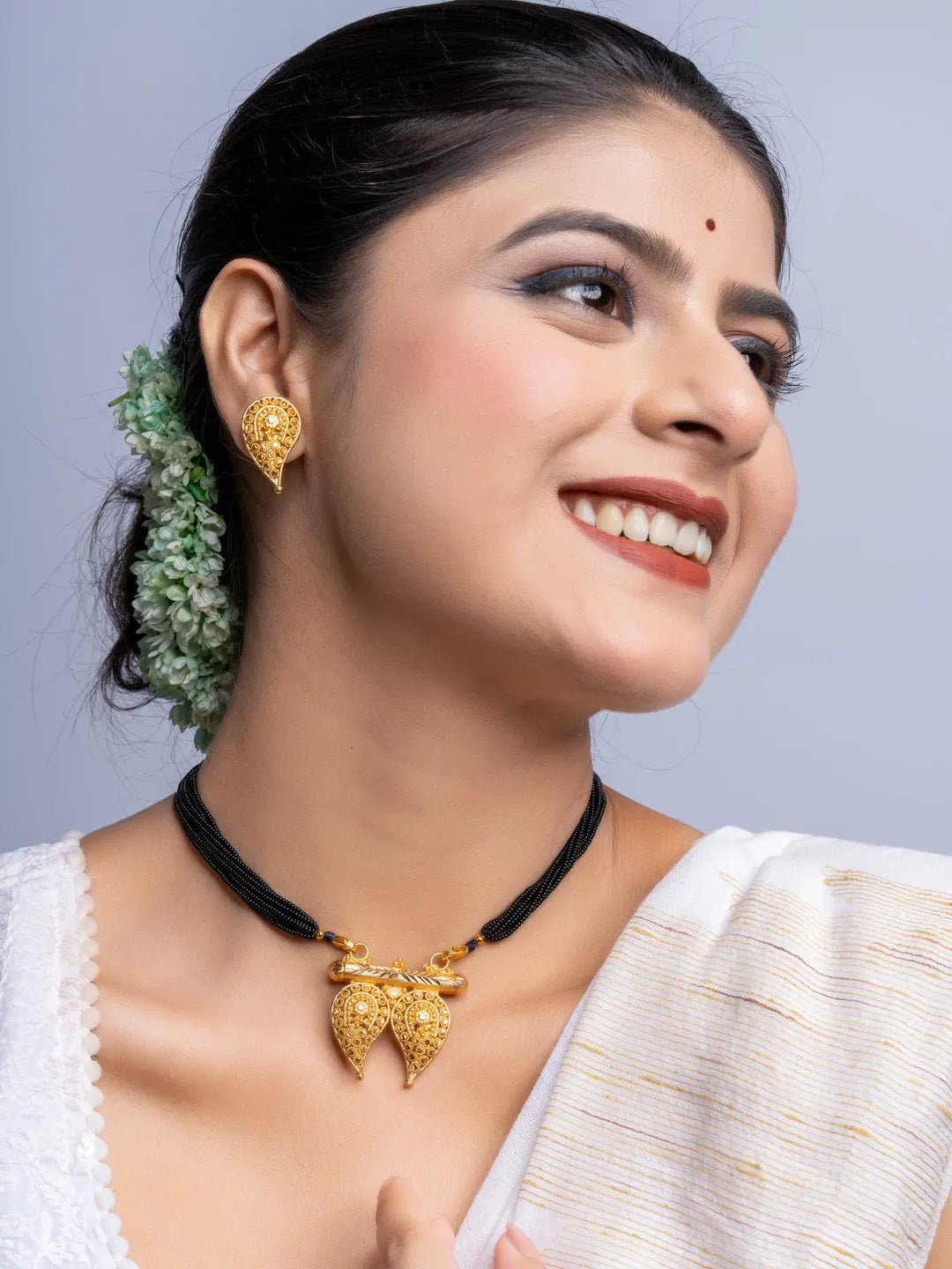 LOOK AND ADORN gold plated traditional earrings and necklace set worn by smiling woman