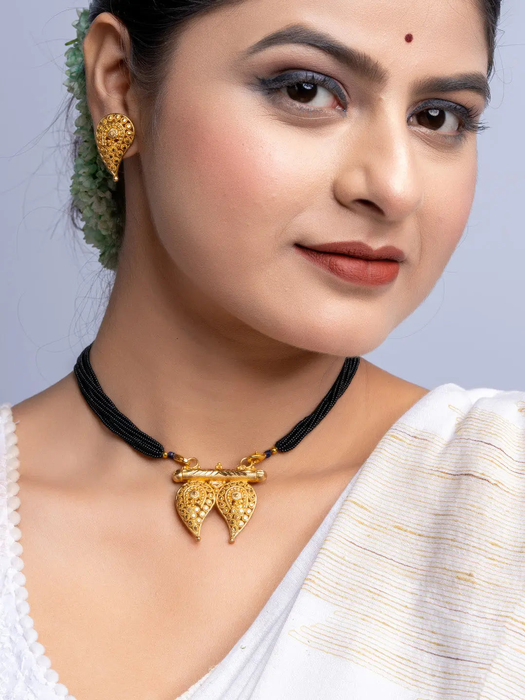 LOOK AND ADORN gold plated necklace and earrings set worn by woman with traditional white saree