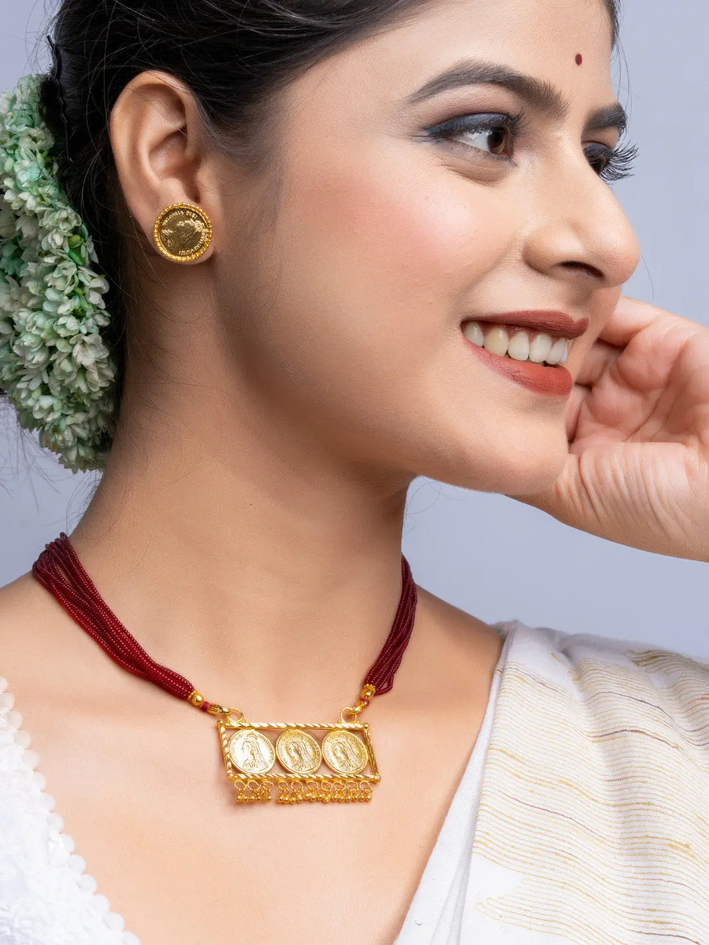 Woman wearing gold plated necklace set with red thread and traditional coin pendant from LOOK AND ADORN