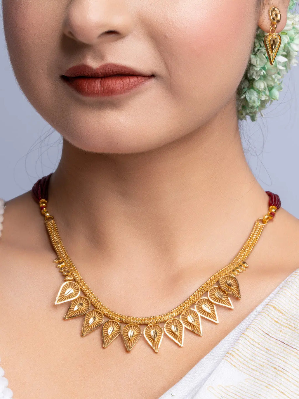 Elegant Gold Plated Necklace Set with intricate leaf designs worn by woman with floral hair accessory