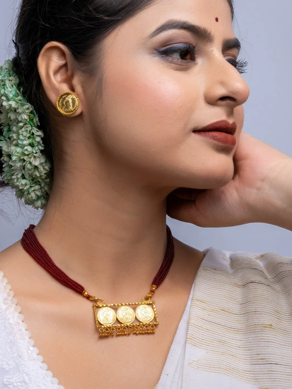 Elegant gold plated necklace set with traditional pendant and matching earrings worn by woman