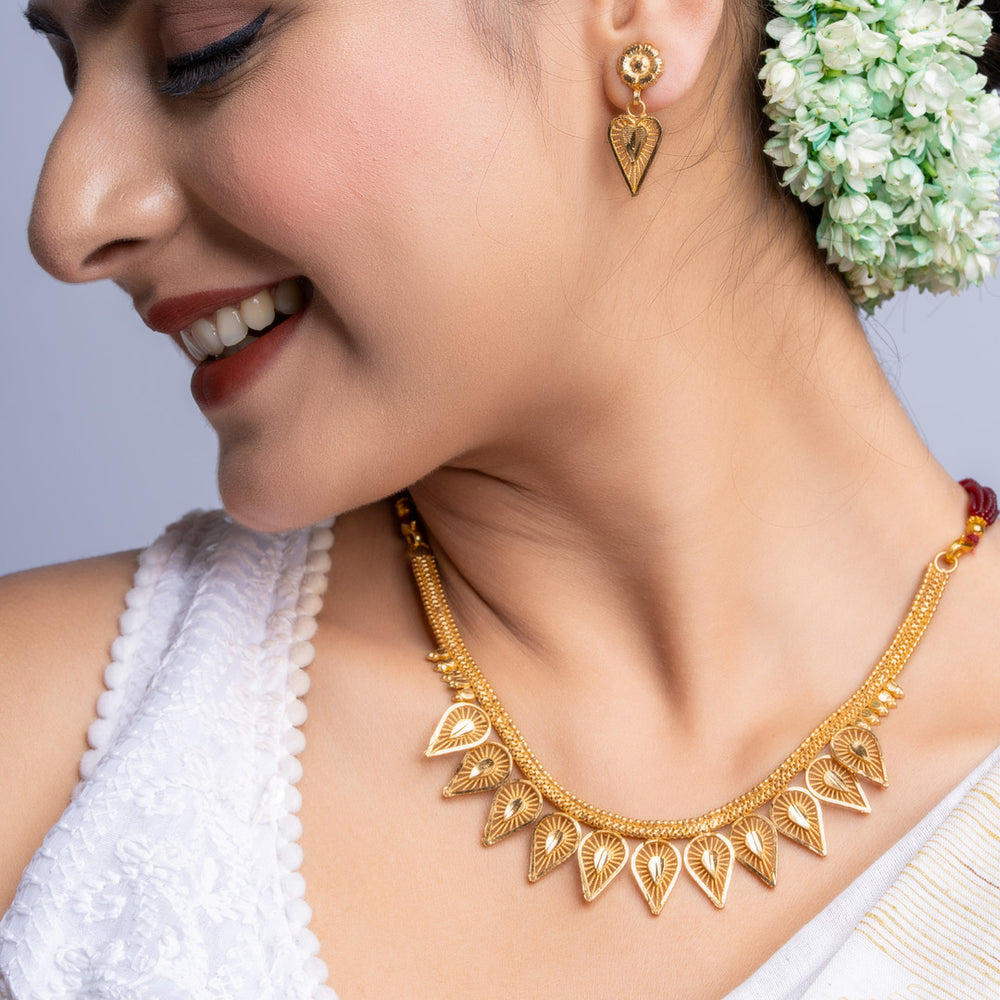 Gold Plated Necklace Set with intricate design worn by woman in traditional attire and floral hair accessory